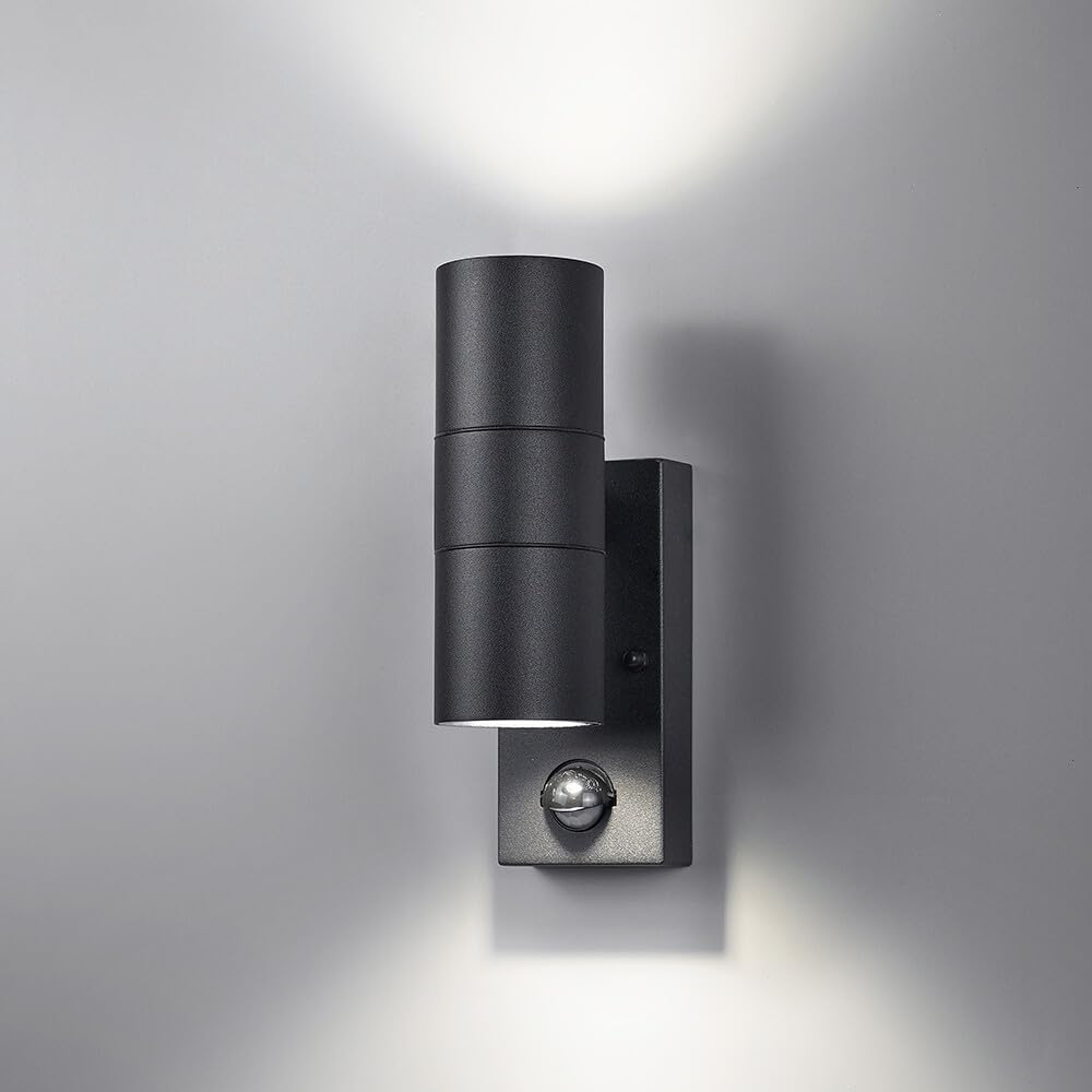 Eine schwarze Wandleuchte mit zwei Zylindern und Bewegungsmelder auf grauem Hintergrund.