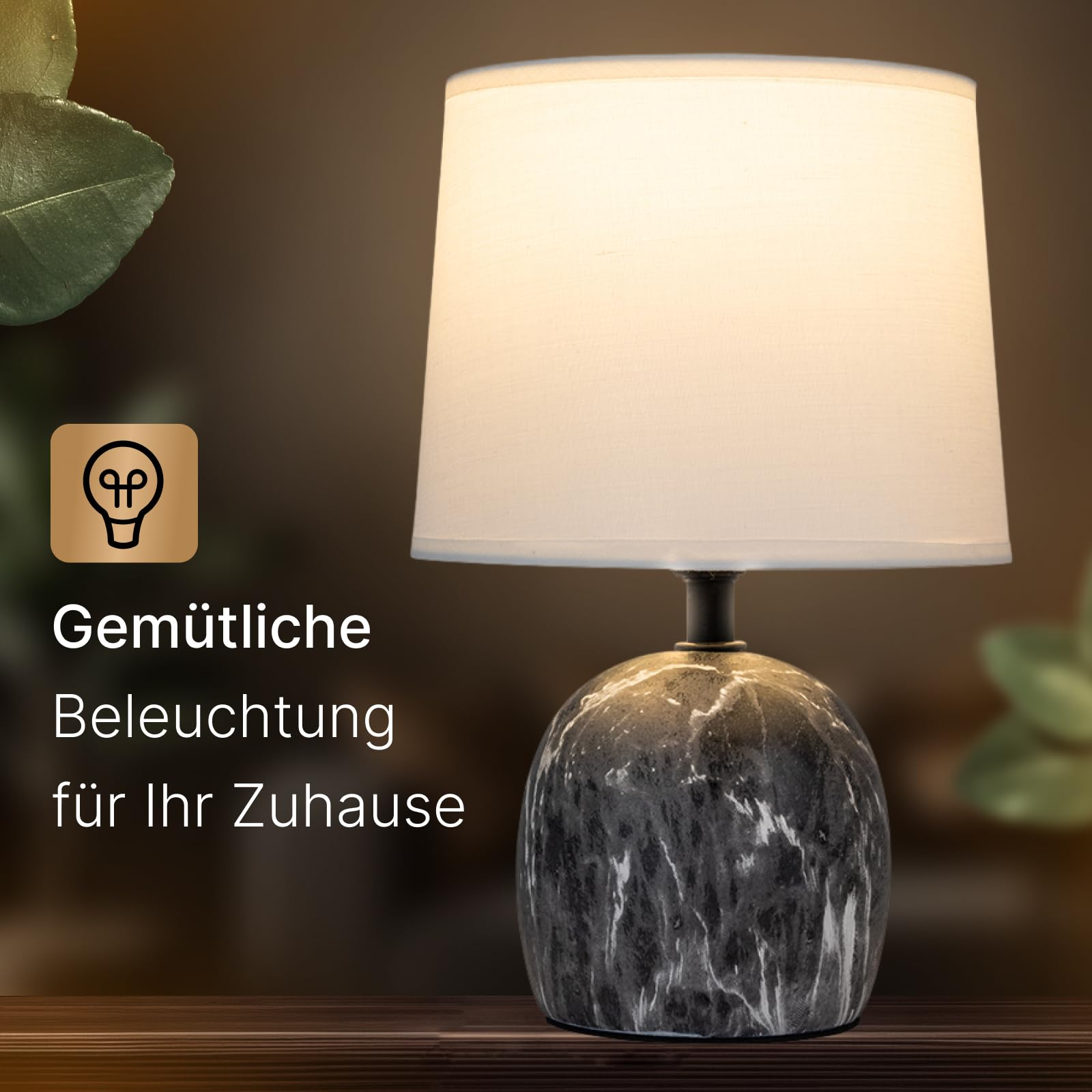 Eine Marmor-Tischlampe mit weißem Schirm und einem Glühbirnen-Symbol.