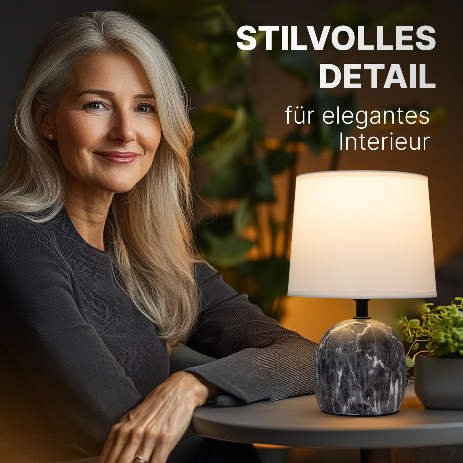 Eine Frau mit grauen Haaren sitzt neben einer Lampe mit Marmorsockel.