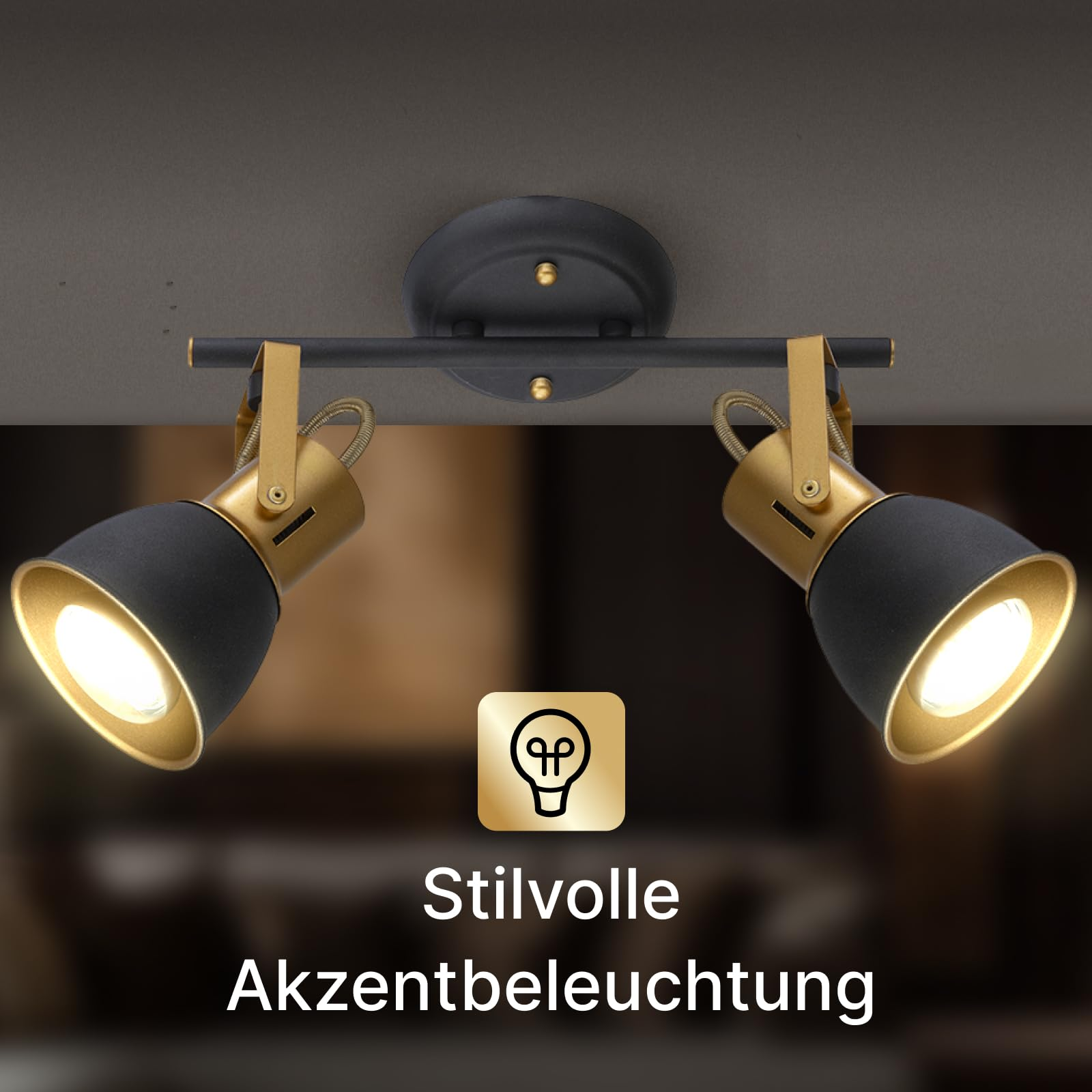Zwei schwenkbare Deckenstrahler mit schwarzem und goldenem Finish beleuchten den Raum.