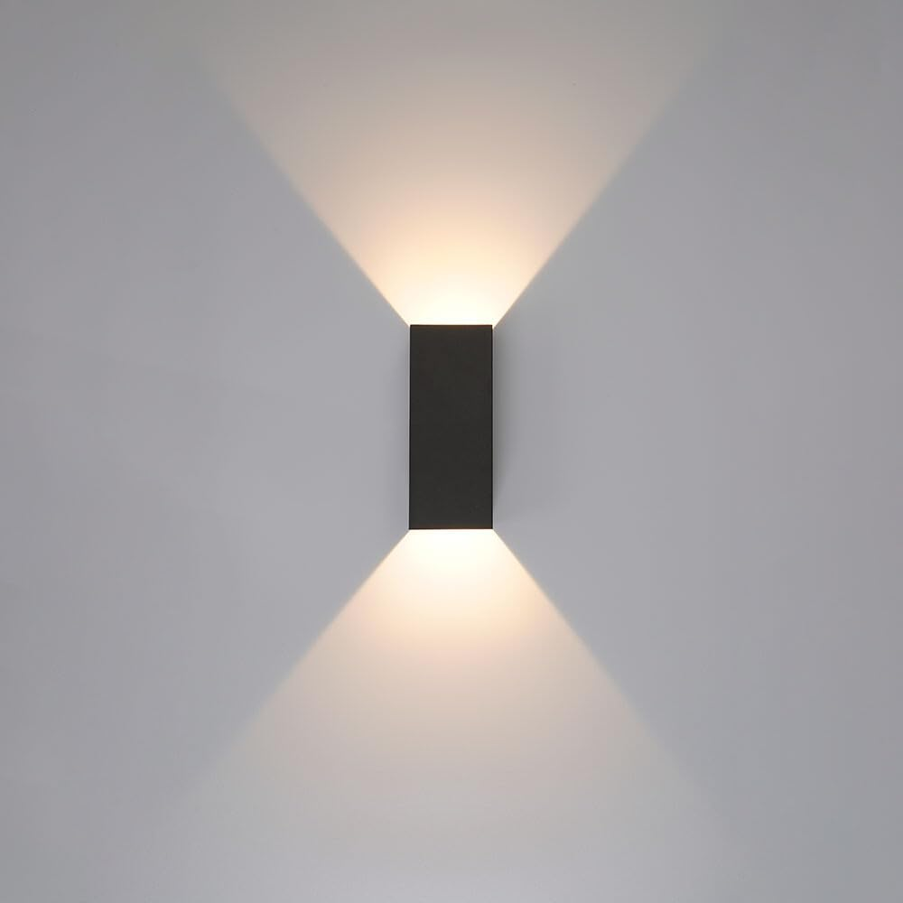 Schwarzer moderner Wandleuchter leuchtet nach oben und unten auf weiße Wand.