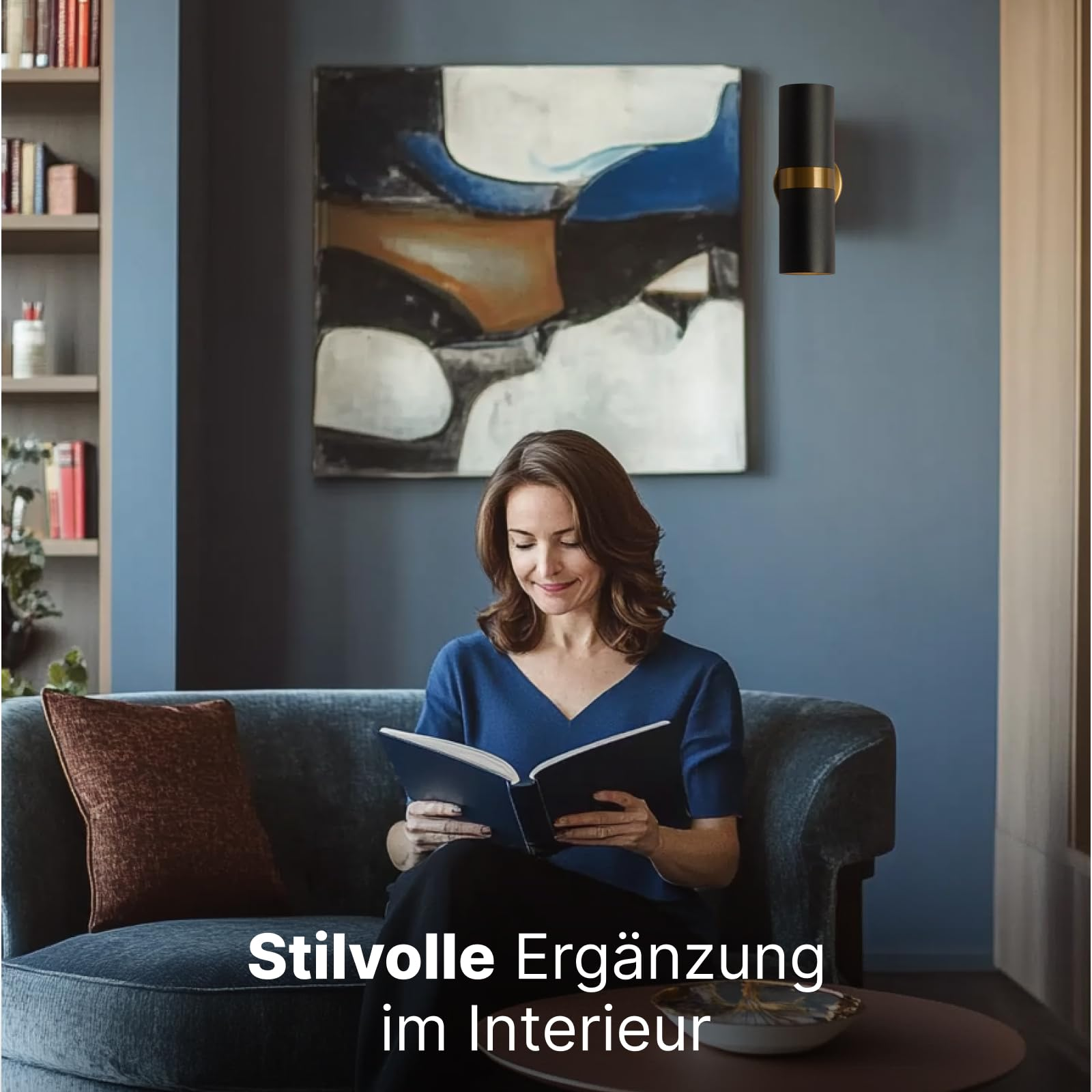 Frau liest Buch auf Sofa vor einem Gemälde und Bücherregal.