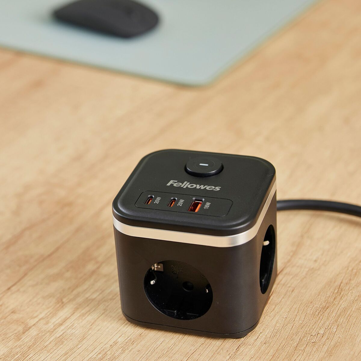 Schwarzer Stromverteiler mit USB-Anschlüssen und Steckdosen auf einem Holztisch.