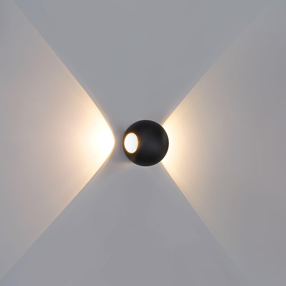 Eine schwarze Kugelwandleuchte wirft Licht nach oben und unten.