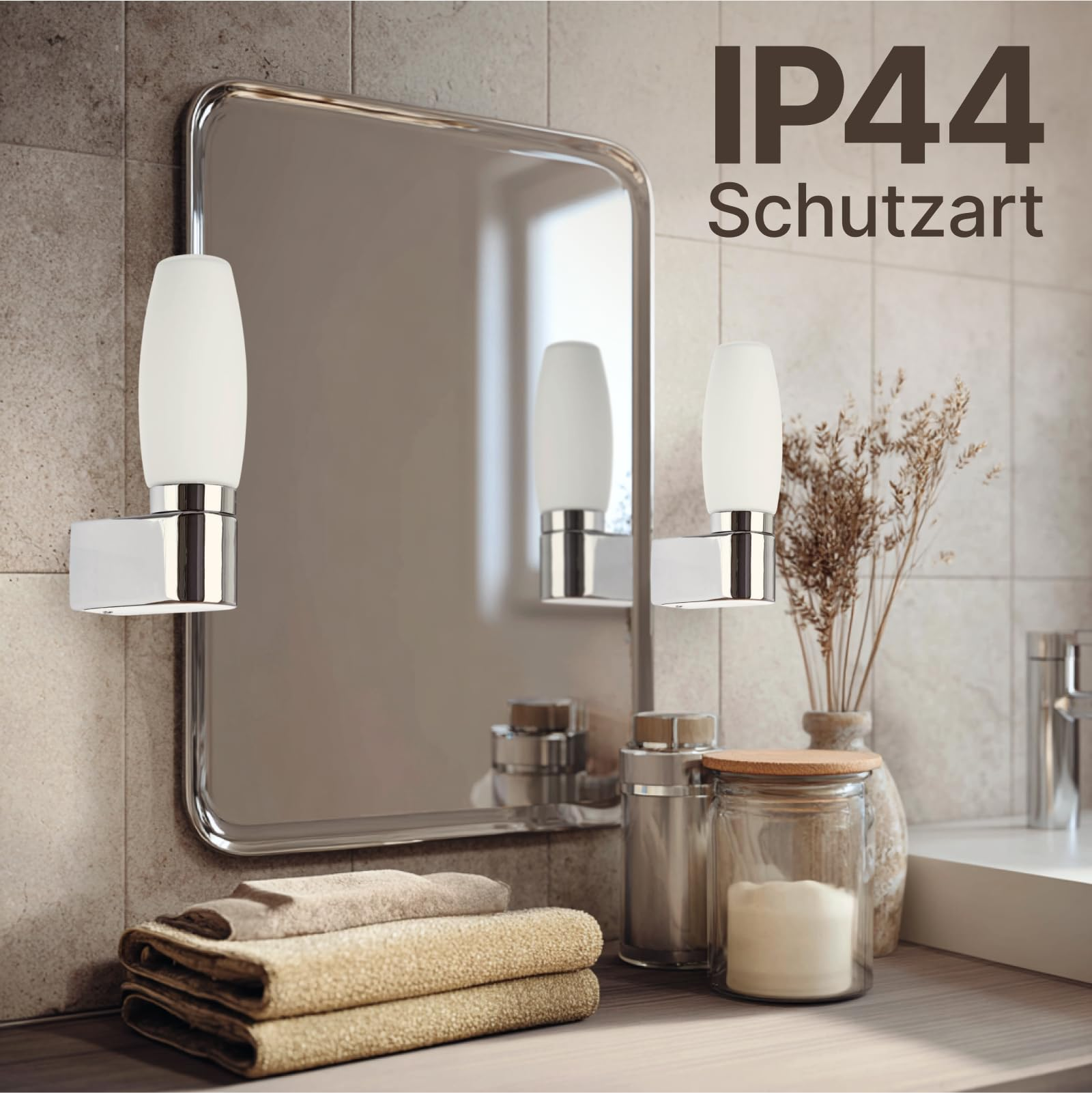 Badezimmerspiegel mit Wandleuchten, Handtüchern und dekorativen Gläsern.