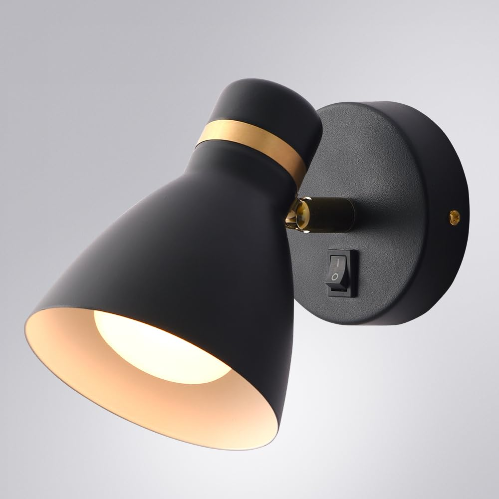 Eine schwarze Wandleuchte mit goldenem Ring und Schalter.