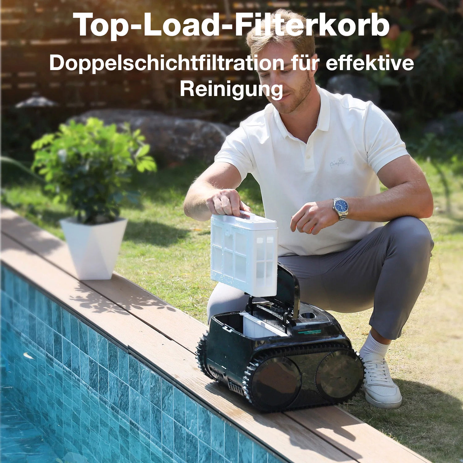 Mann reinigt Poolroboter-Filterkorb am Poolrand mit Rasen und Pflanze im Hintergrund.