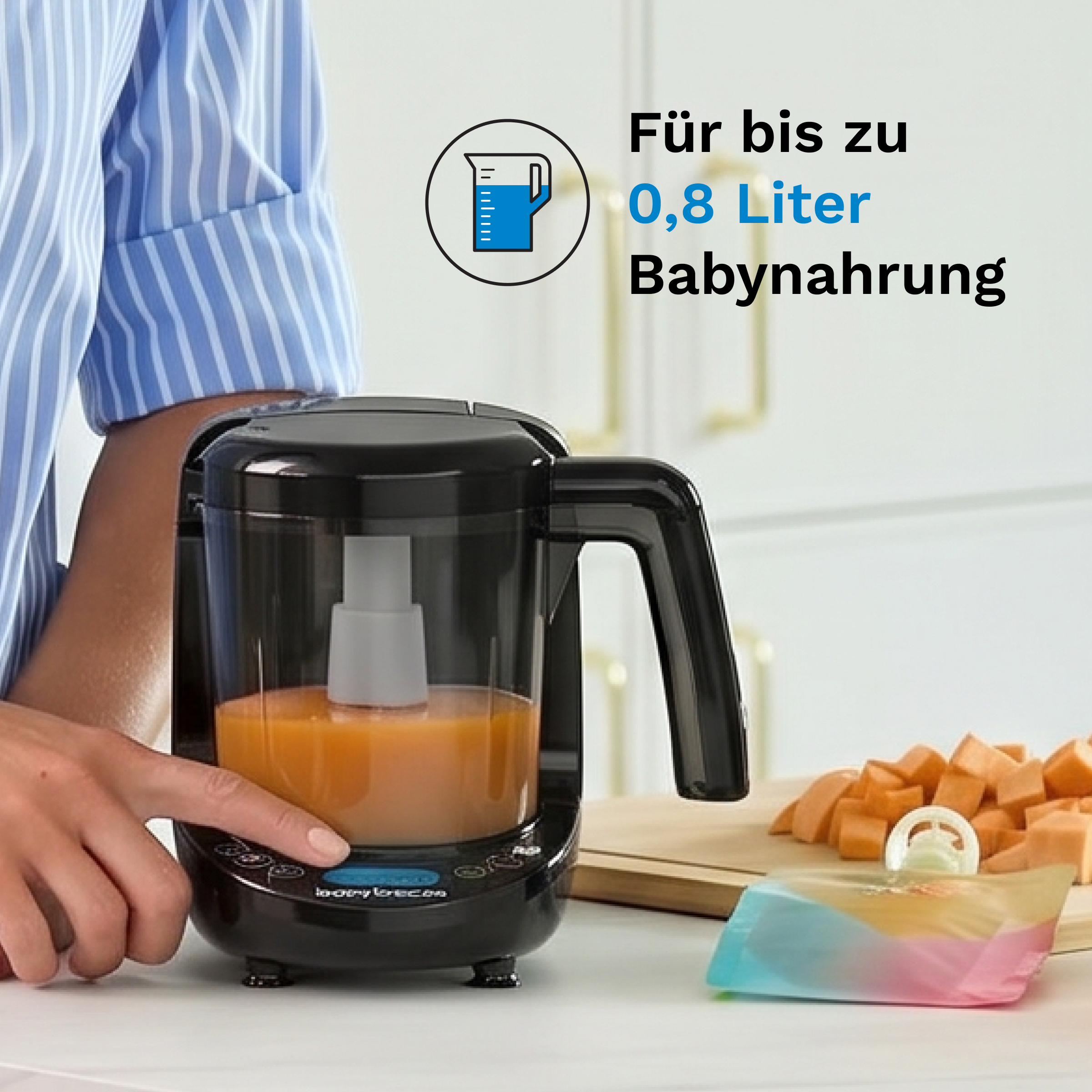 Ein Babybrei-Zubereiter mit Orangenbrei und Würfeln von Süßkartoffeln.