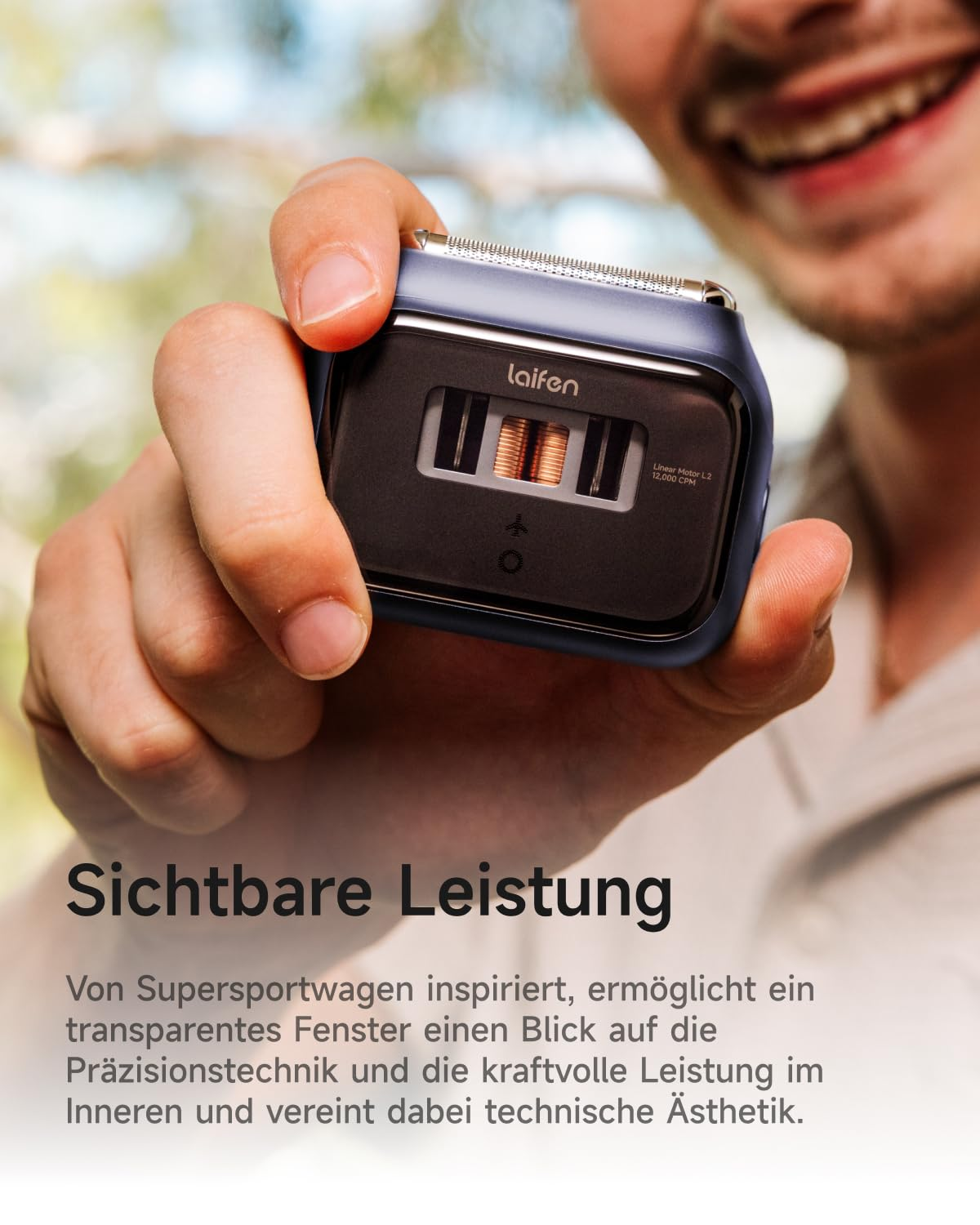 Mann hält blauen Rasierer mit transparentem Fenster, das Kupferrotoren zeigt.