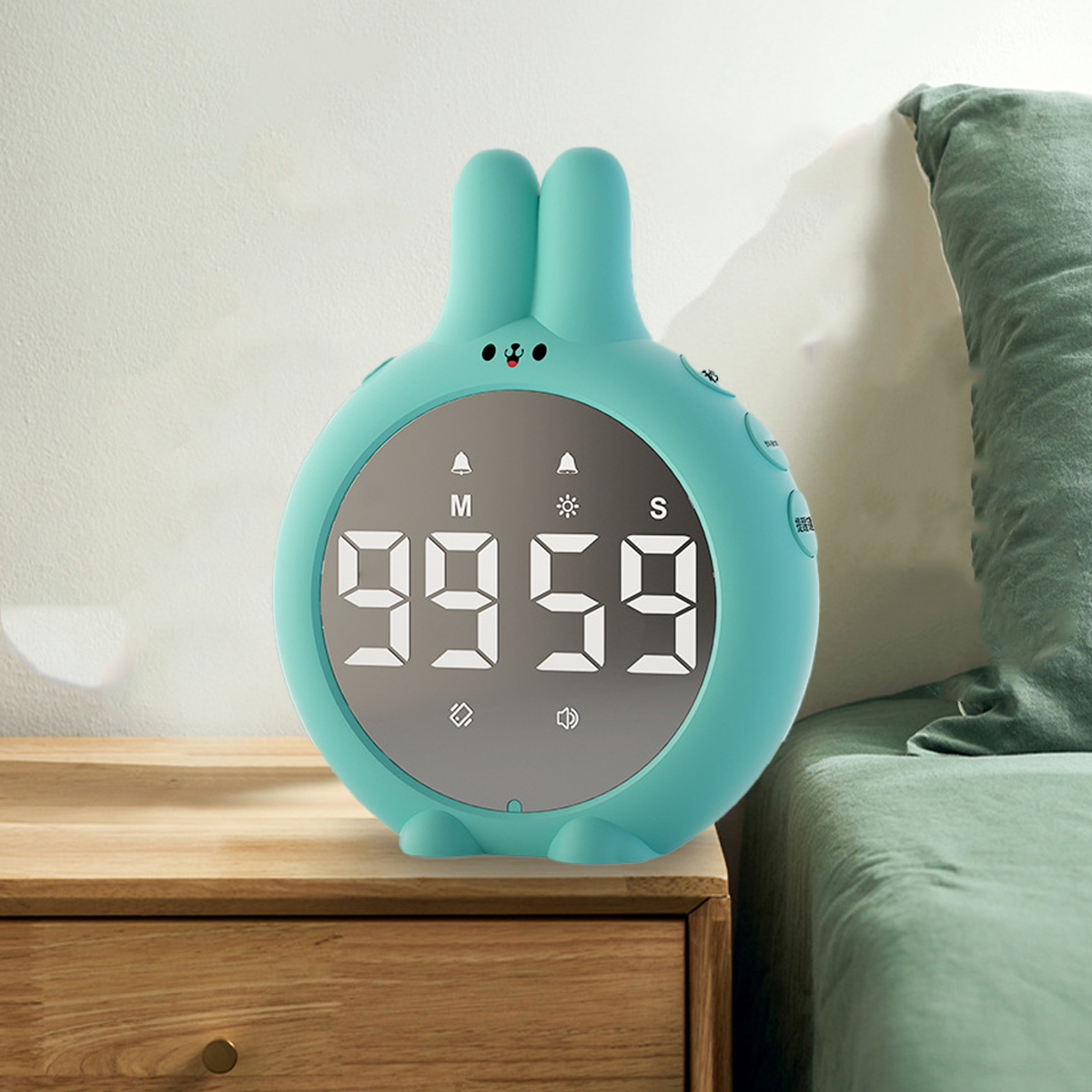 Ein tealfarbener Timer in Hasenform zeigt 99:59 auf einem Nachttisch an.