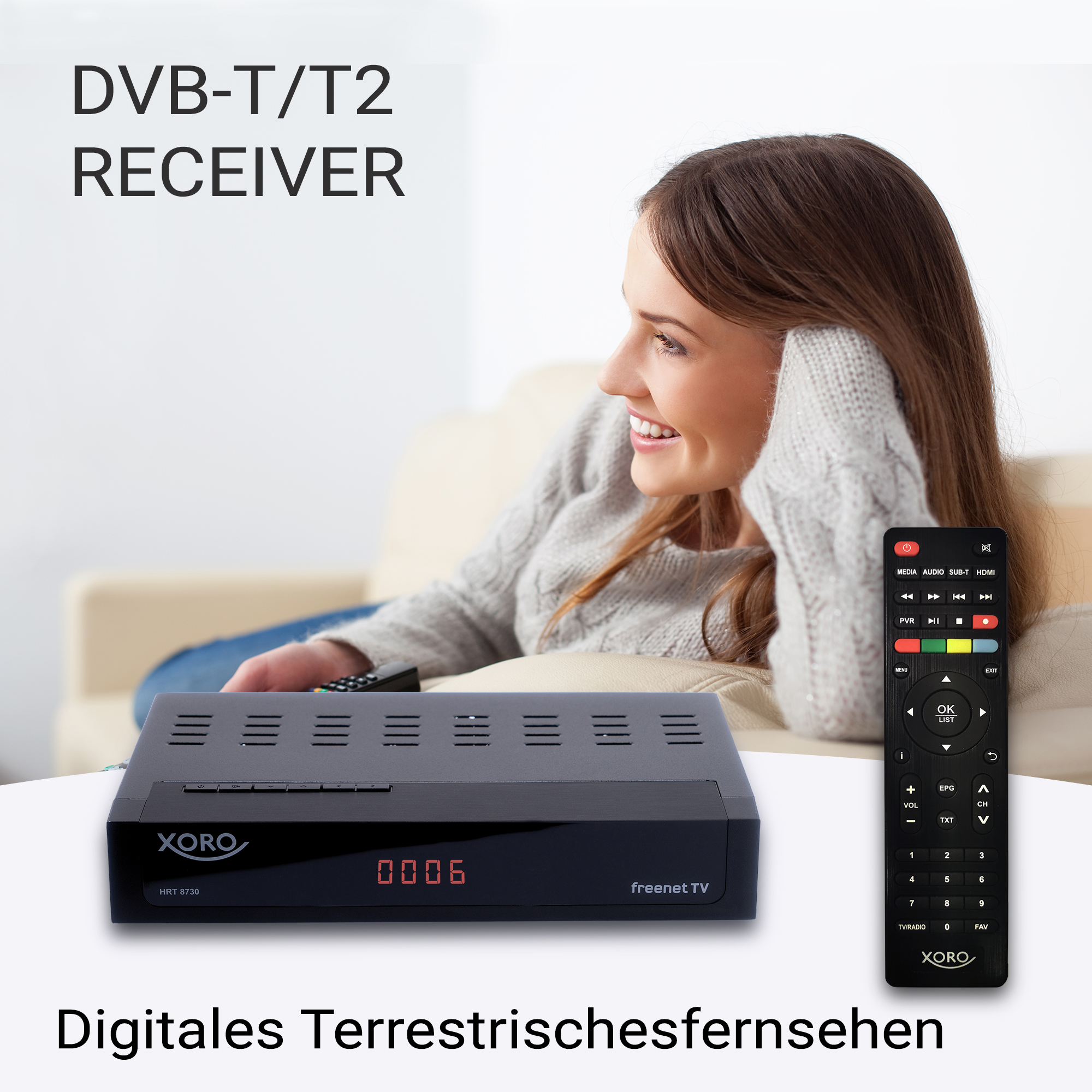 Ein DVB-T/T2-Receiver mit Fernbedienung auf einem Tisch, eine Frau im Hintergrund.