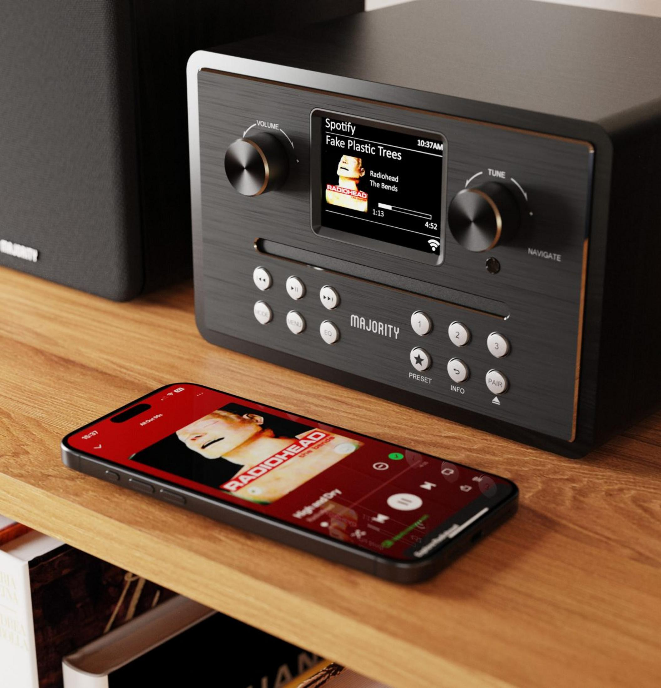 Un stereo nero suona Radiohead, accanto a uno smartphone con la stessa musica.
