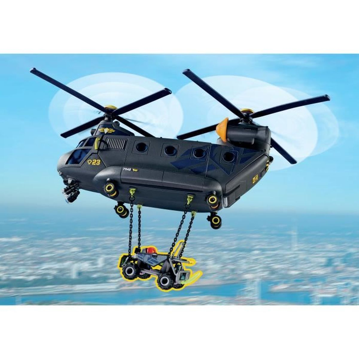 Ein schwarzer Hubschrauber transportiert ein kleines gelbes Fahrzeug in der Luft über einer Stadt.