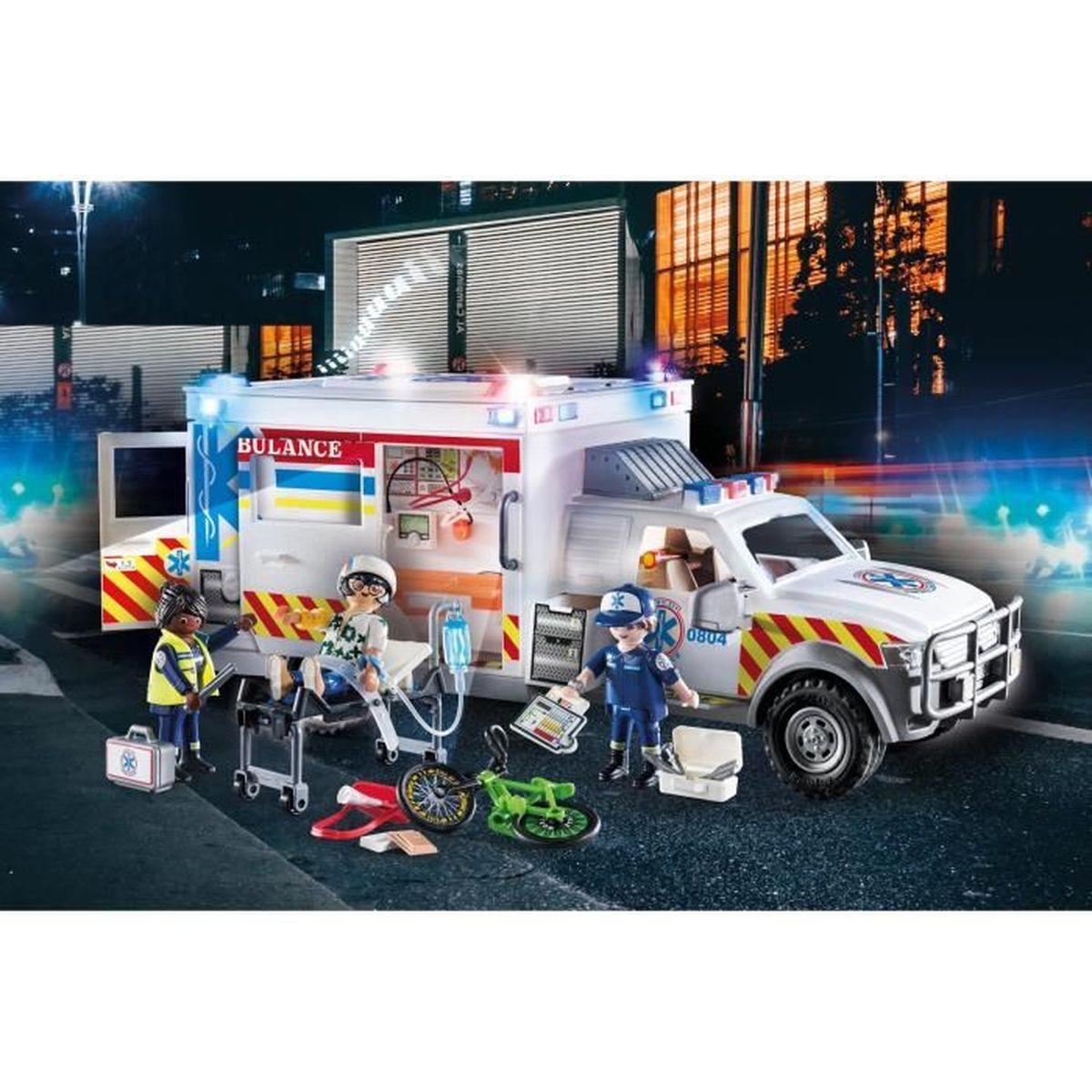 Una ambulancia de juguete con figuras, una camilla y una bicicleta por la noche.