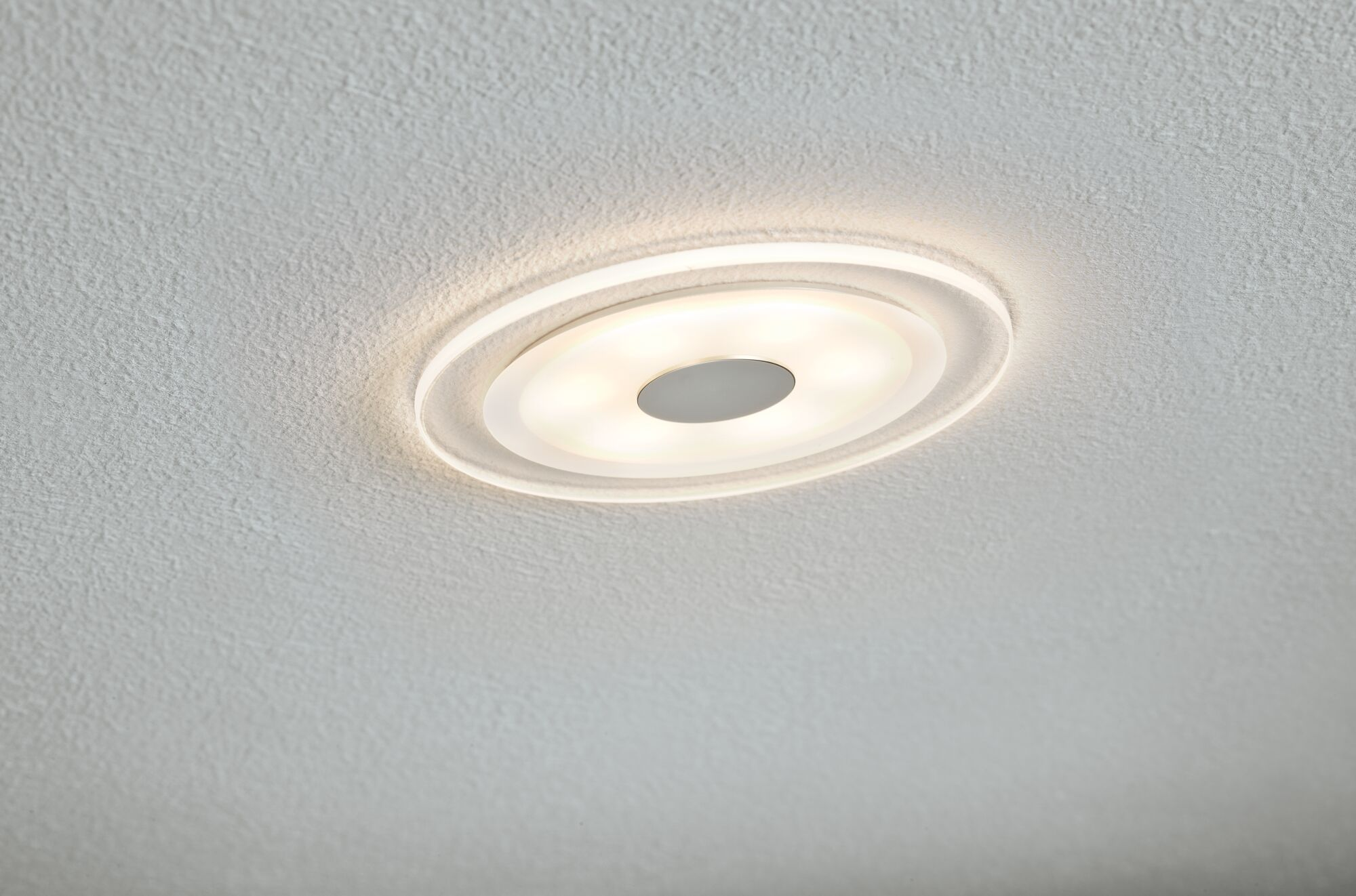 Lampada da soffitto bianca con anelli ed elemento centrale grigio.