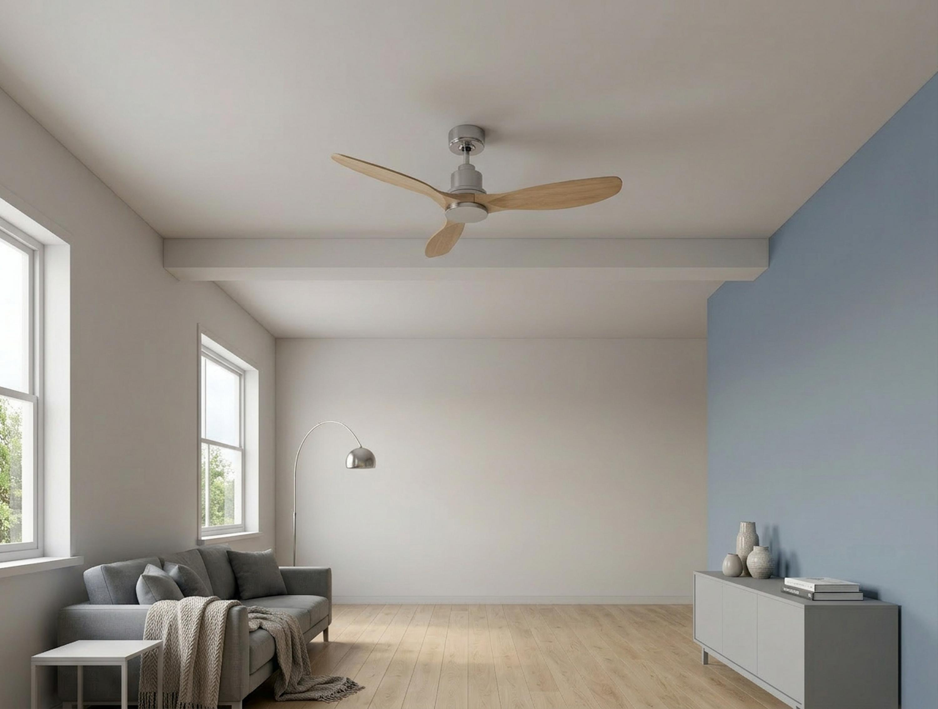 Una sala de estar con sofá, ventilador de techo y mueble.