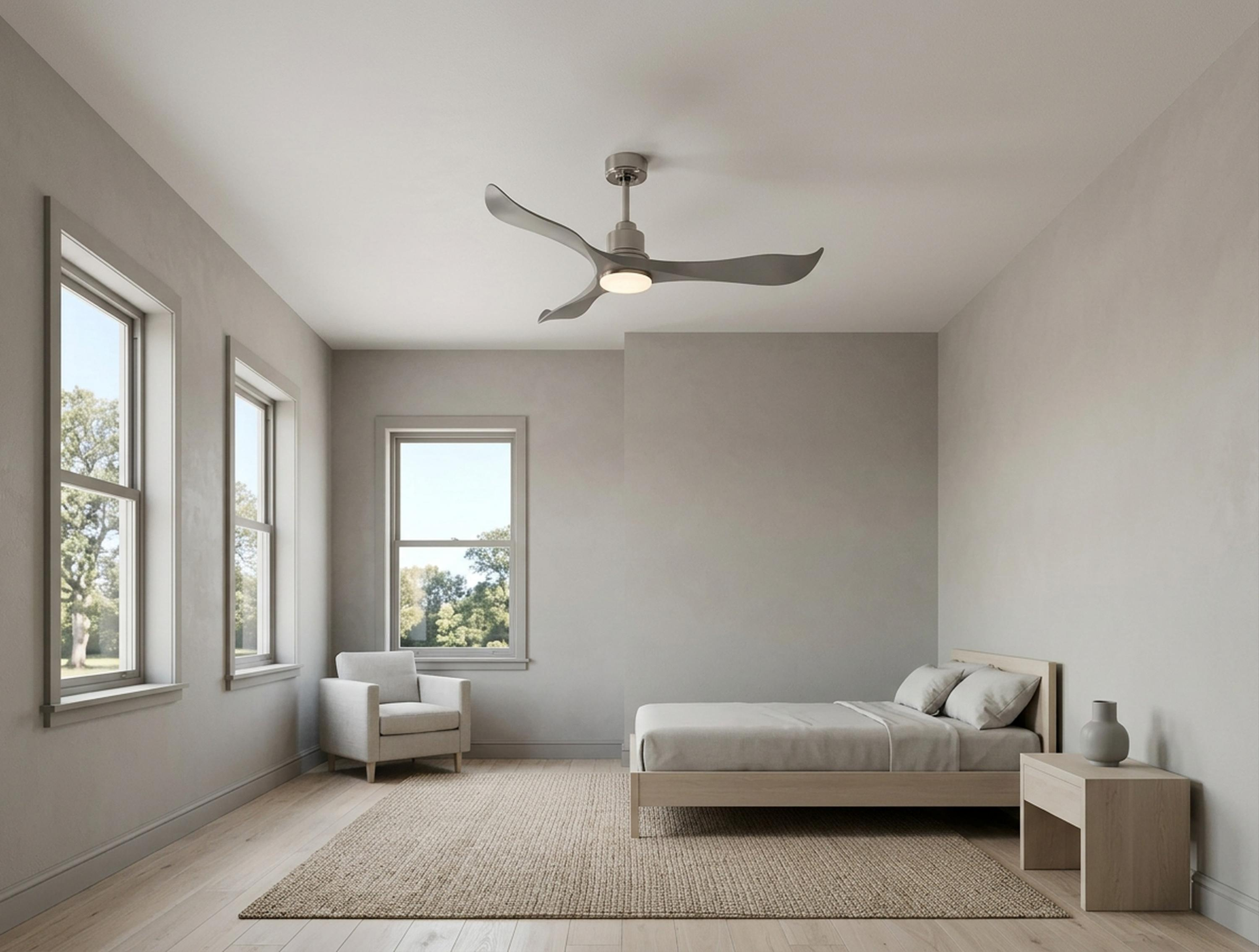Un dormitorio con cama, sillón, ventilador de techo y ventanas.
