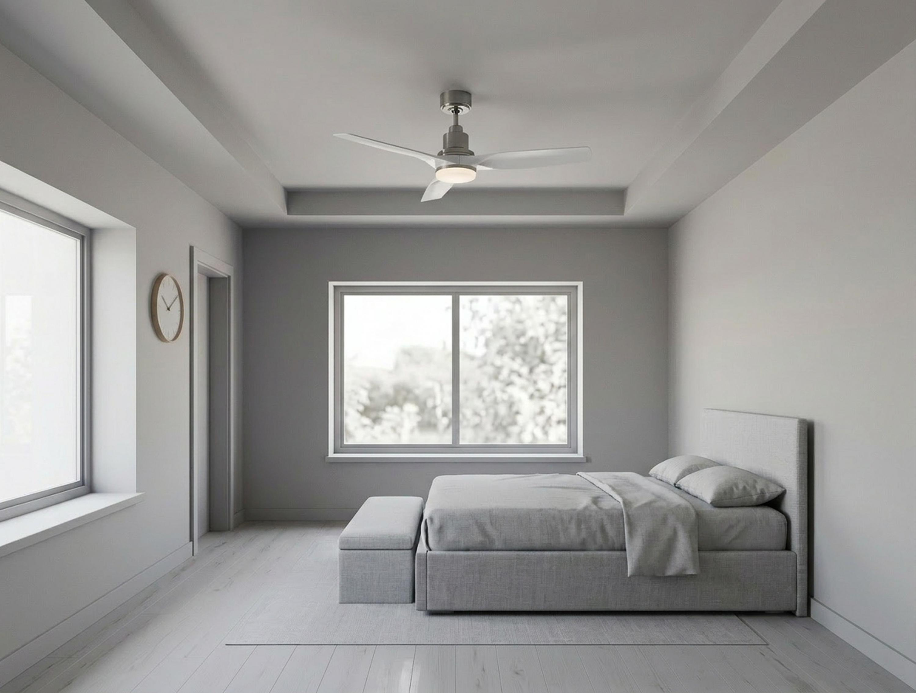 Dormitorio gris con cama, ventilador de techo y dos ventanas.