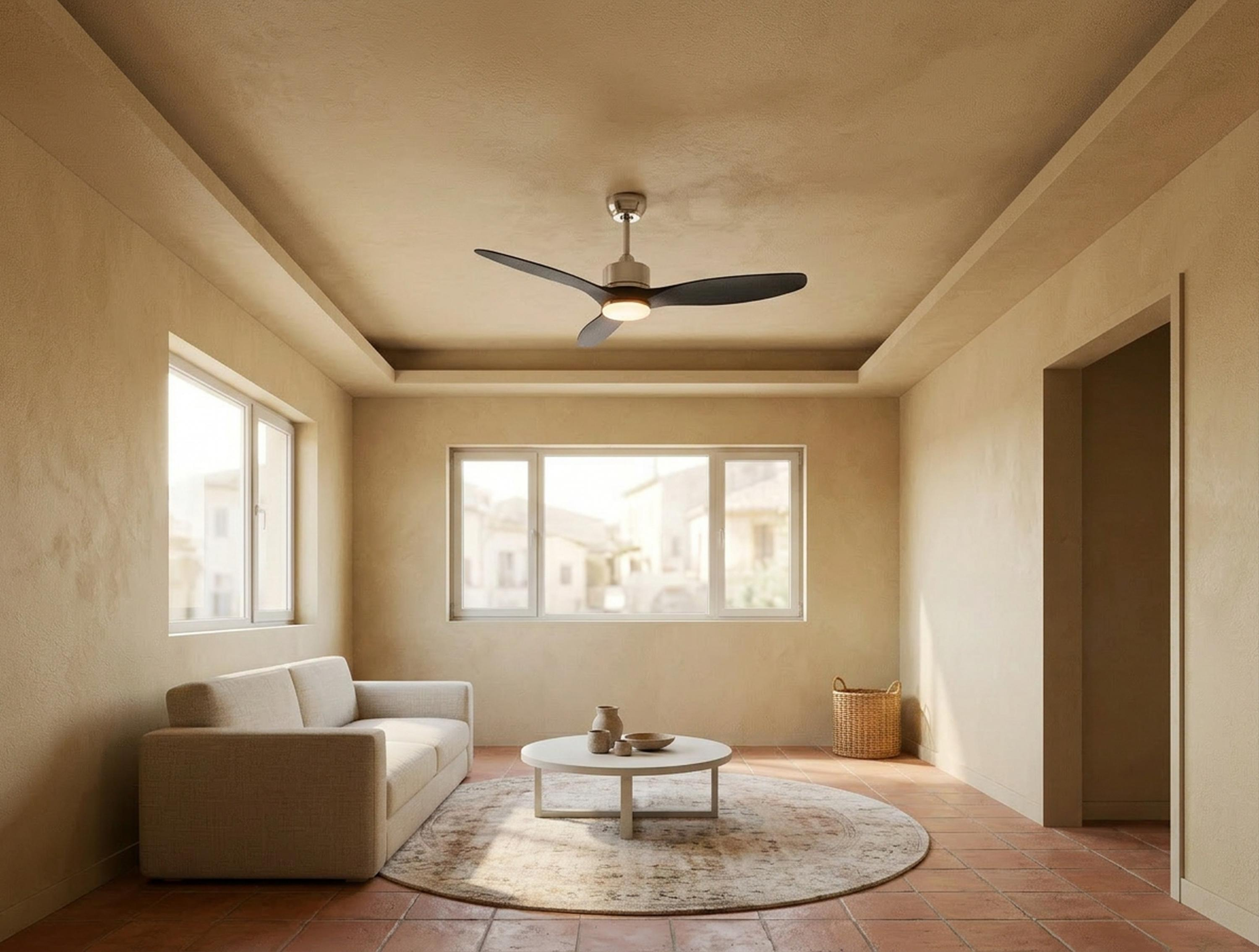 Una sala de estar luminosa con sofá, mesa de centro, ventilador de techo y ventanas.