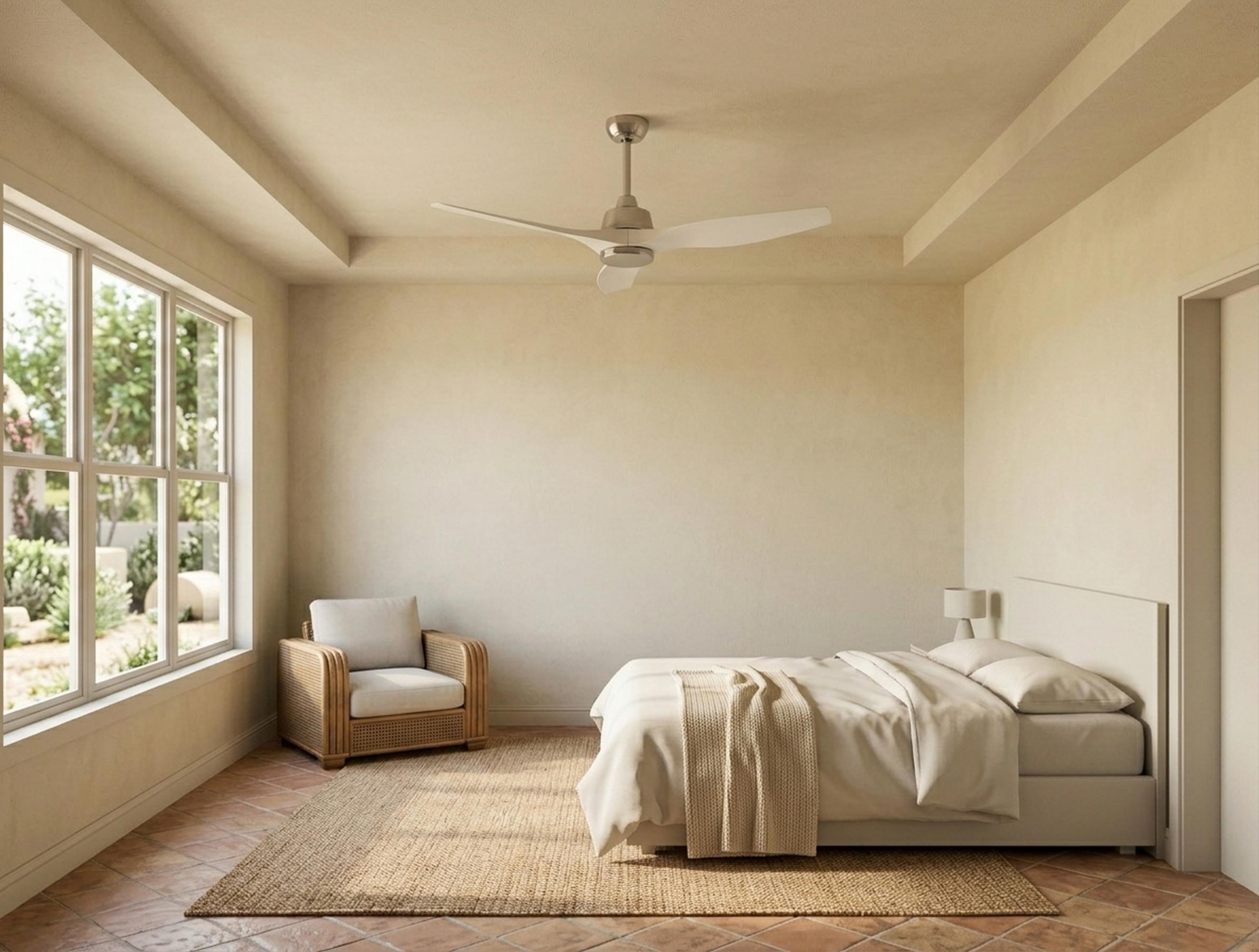 Un dormitorio con cama, sillón, ventilador de techo y gran ventana con vista al jardín.