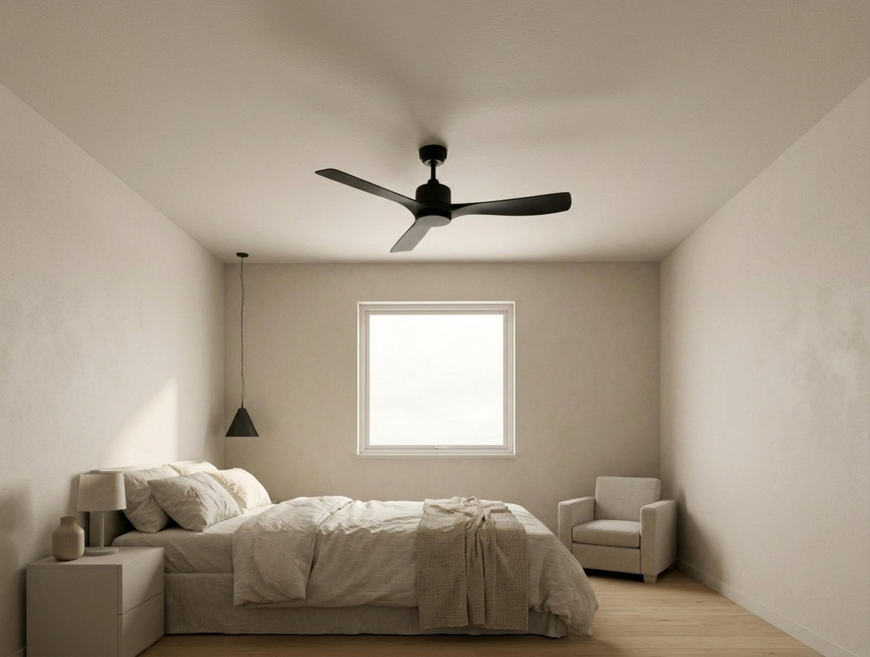 Un dormitorio con cama, sillón, mesita de noche, ventilador de techo y ventana.