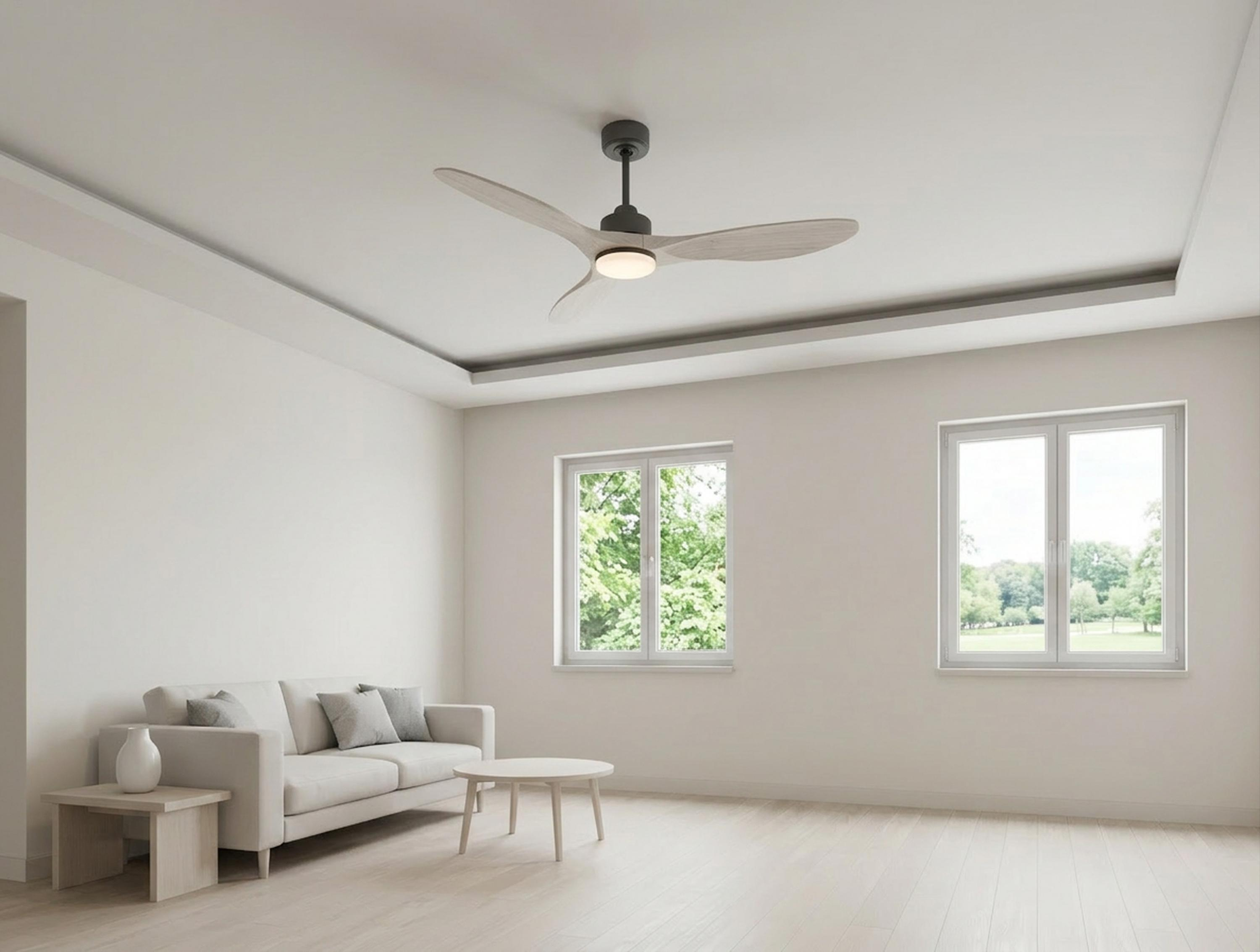 Una sala de estar luminosa con sofá, mesa de centro, ventilador de techo y ventanas con vistas al verde.