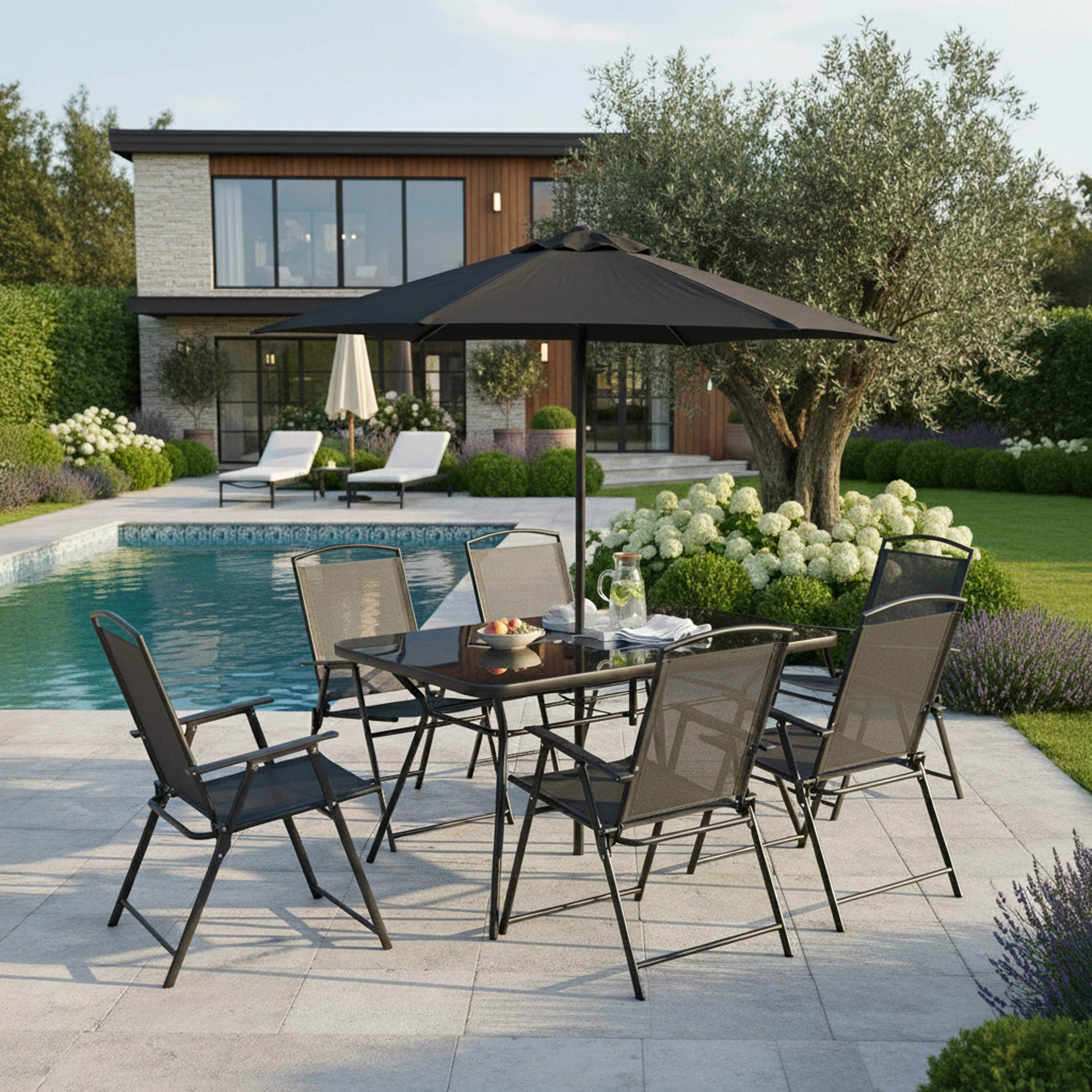 Gartentisch mit Stühlen, Sonnenschirm, Pool und Haus im Hintergrund.