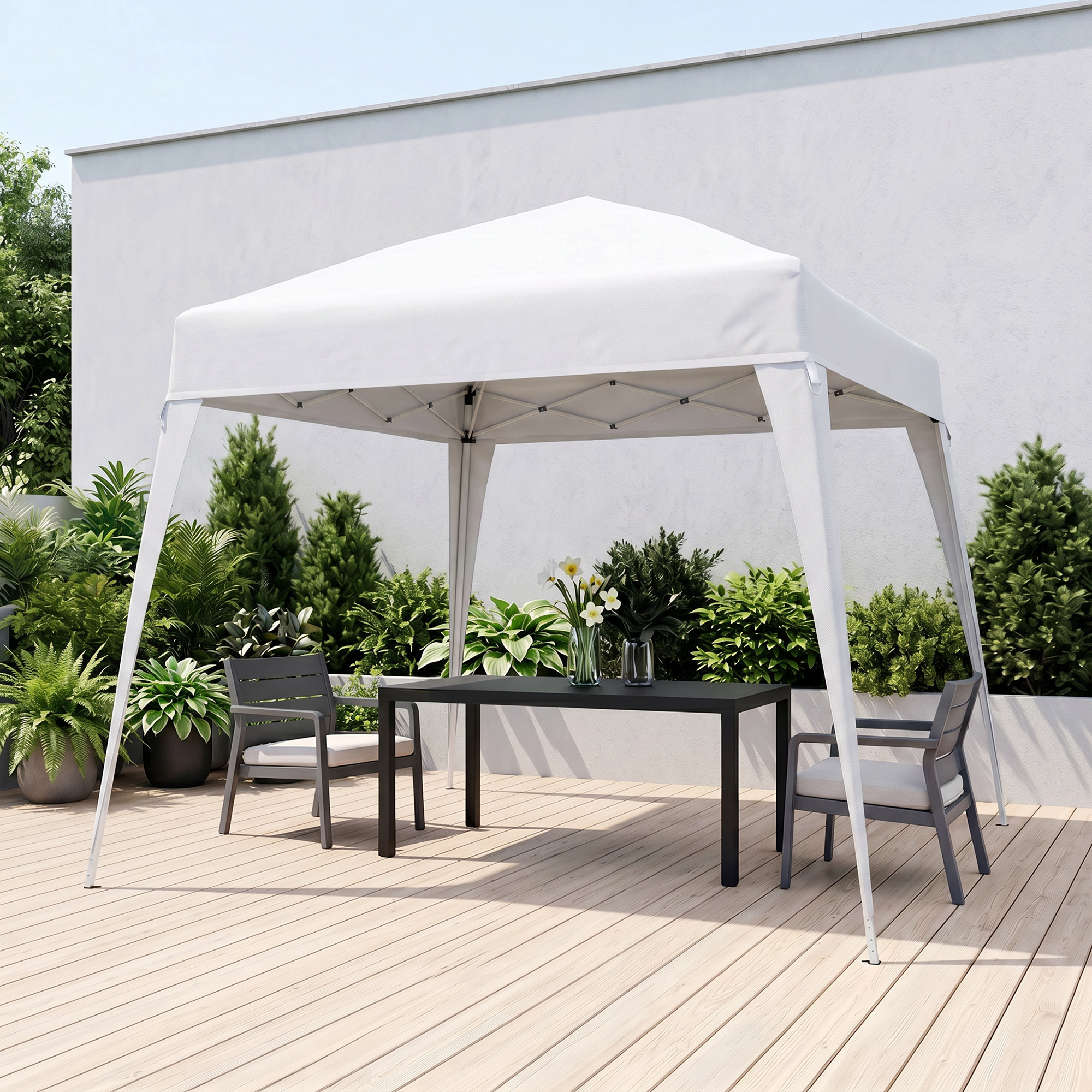 Una carpa blanca está sobre una terraza de madera con una mesa y dos sillas.