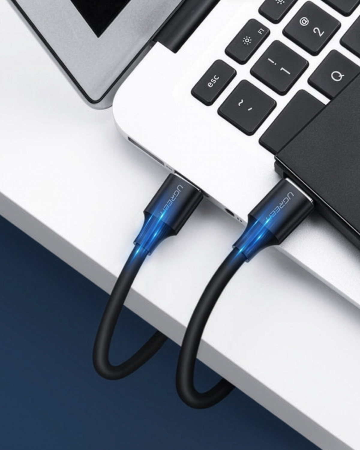 Bir dizüstü bilgisayara ve harici sabit diske bağlı iki siyah USB kablosu.
