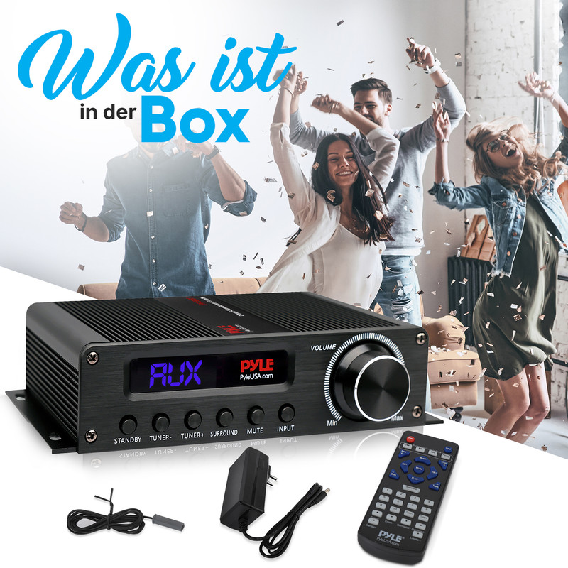 Ein schwarzer Audioverstärker mit Fernbedienung, Netzteil und Antenne. Feiernde Menschen im Hintergrund.