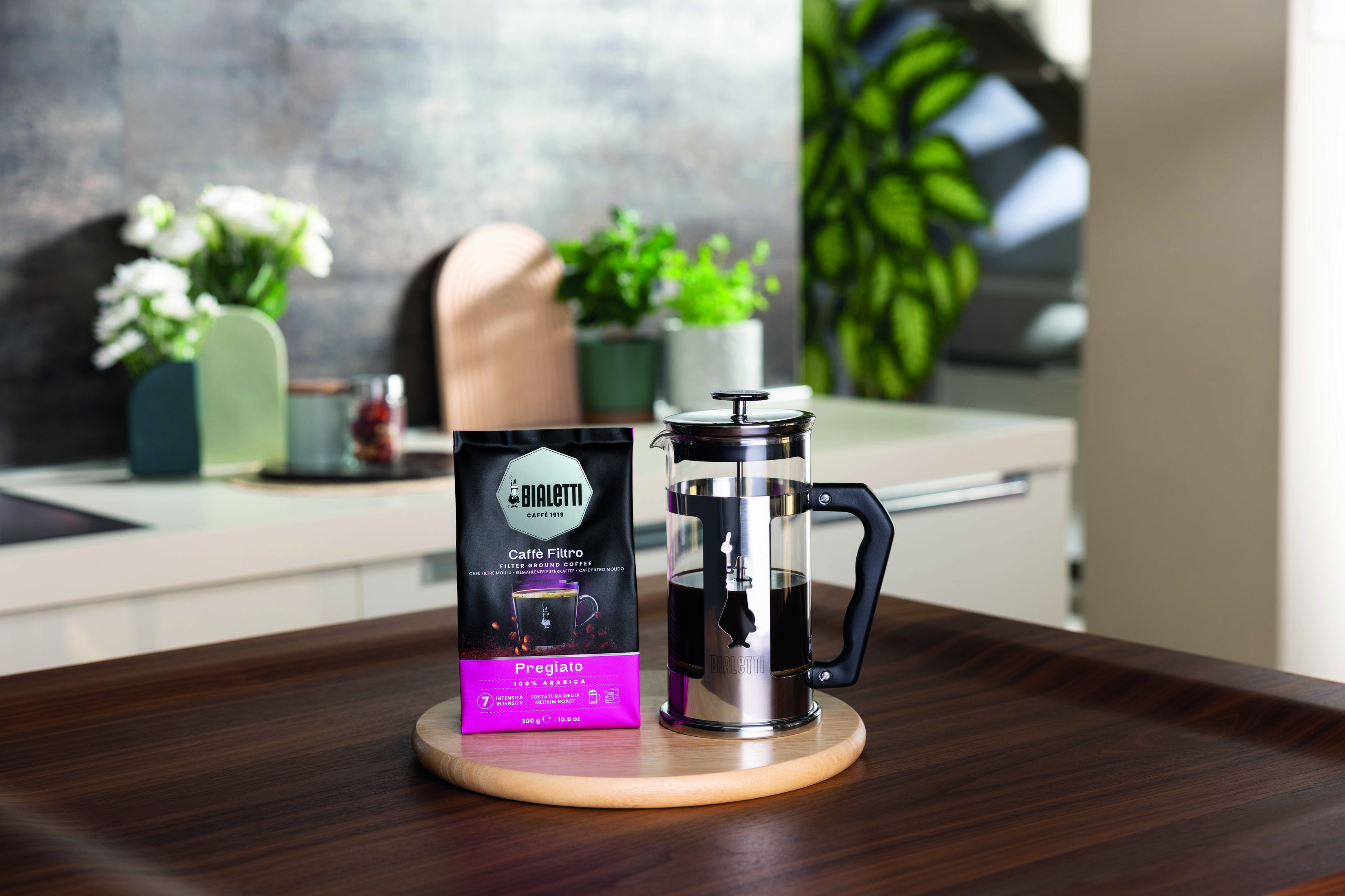 Una busta di Bialetti Caffè Filtro e una caffettiera French press in vetro.