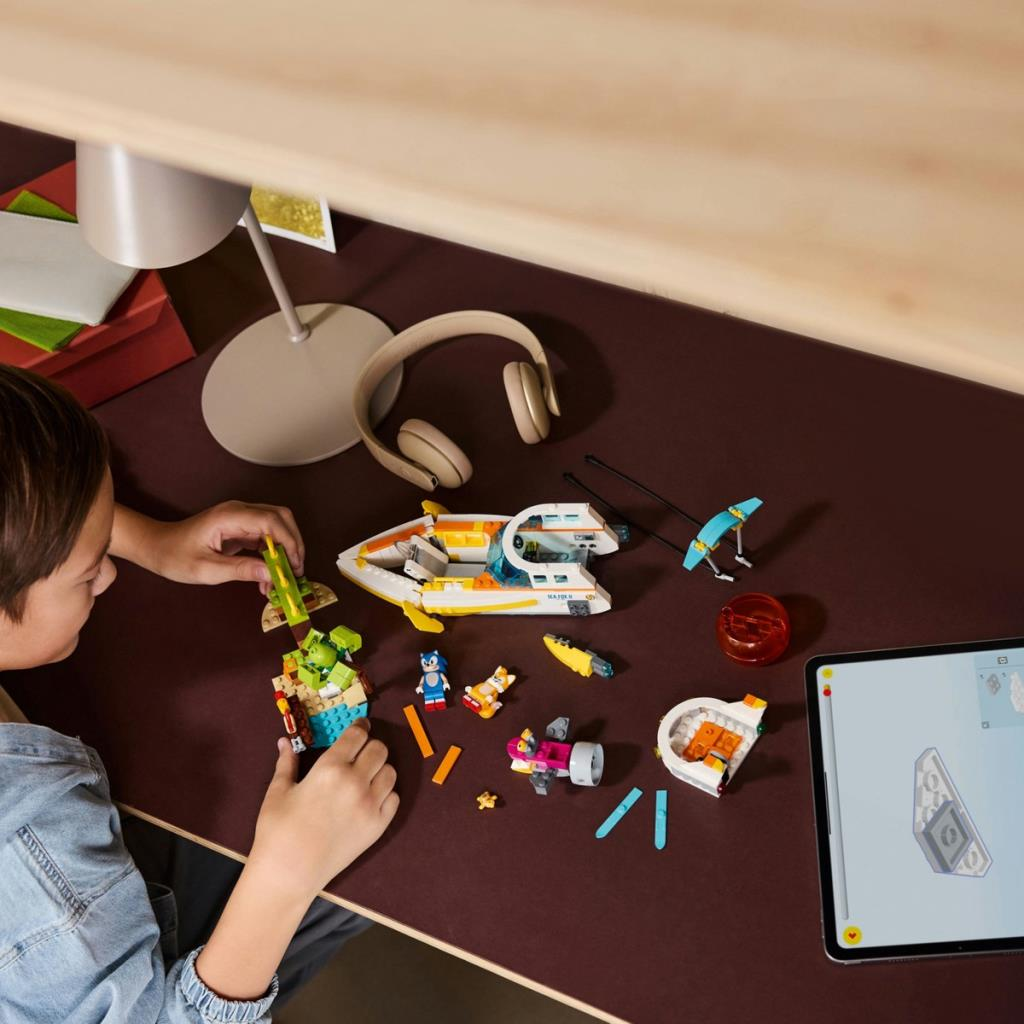 Bir çocuk, tablet talimatları gösterirken Lego tuğlalarıyla inşa ediyor.