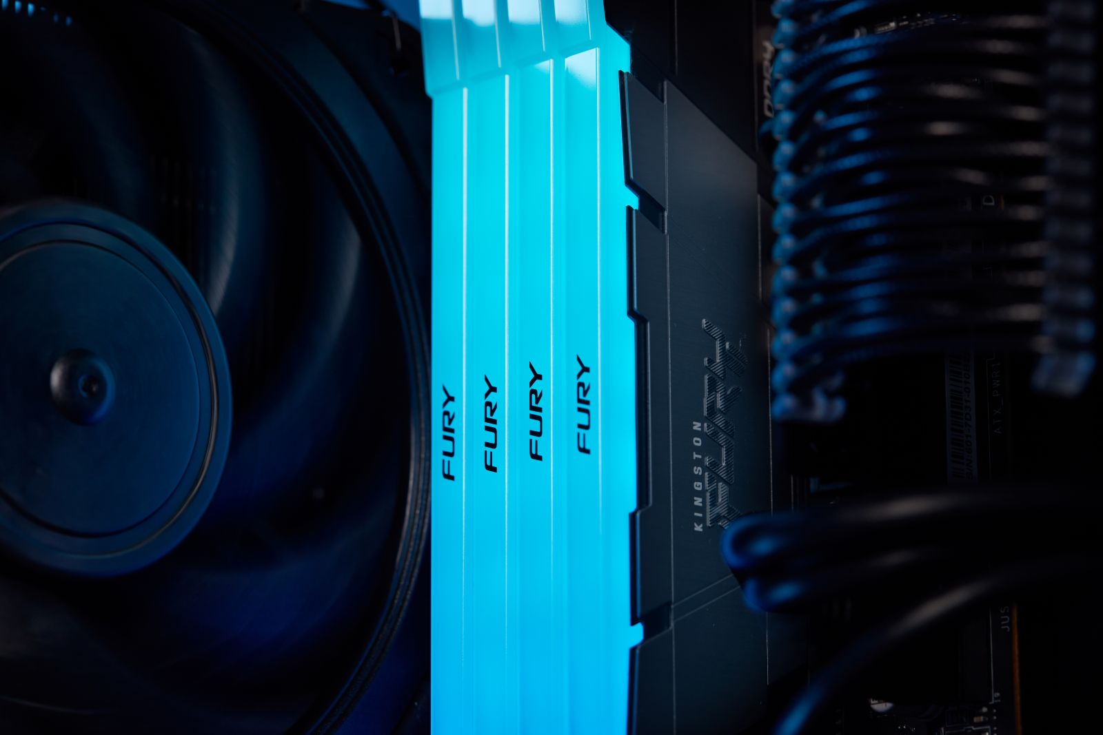Ein Computerlüfter und leuchtende blaue RAM-Riegel mit der Aufschrift FURY.