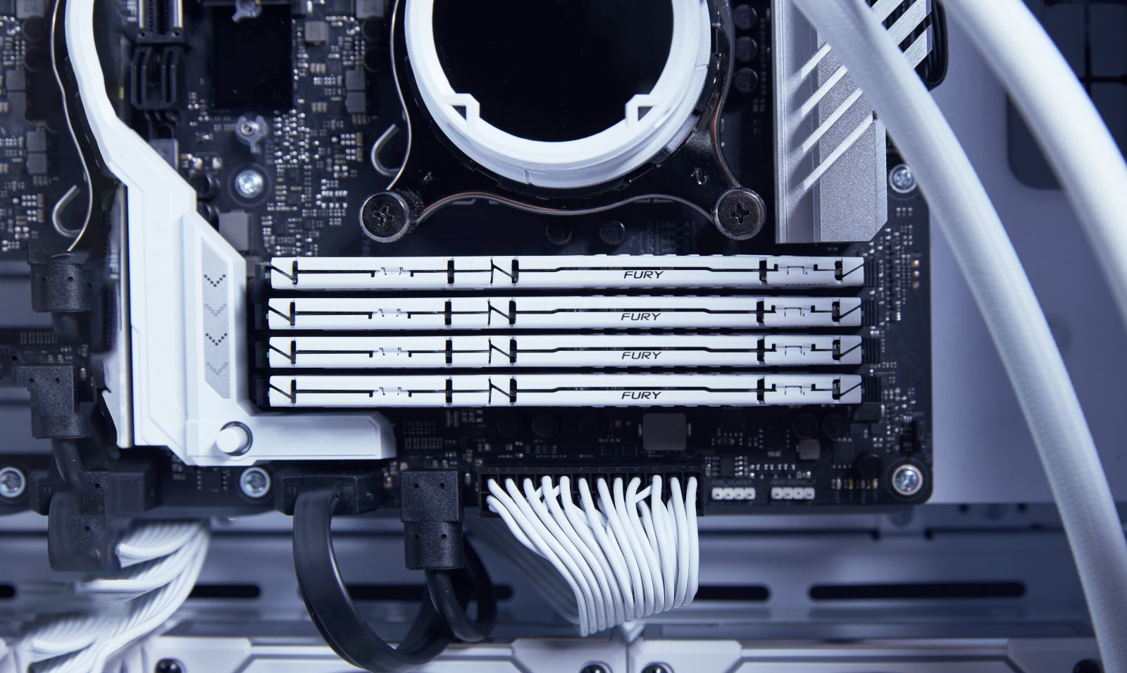 Nahaufnahme eines Computer-Motherboards mit RAM-Riegeln und Kabeln.