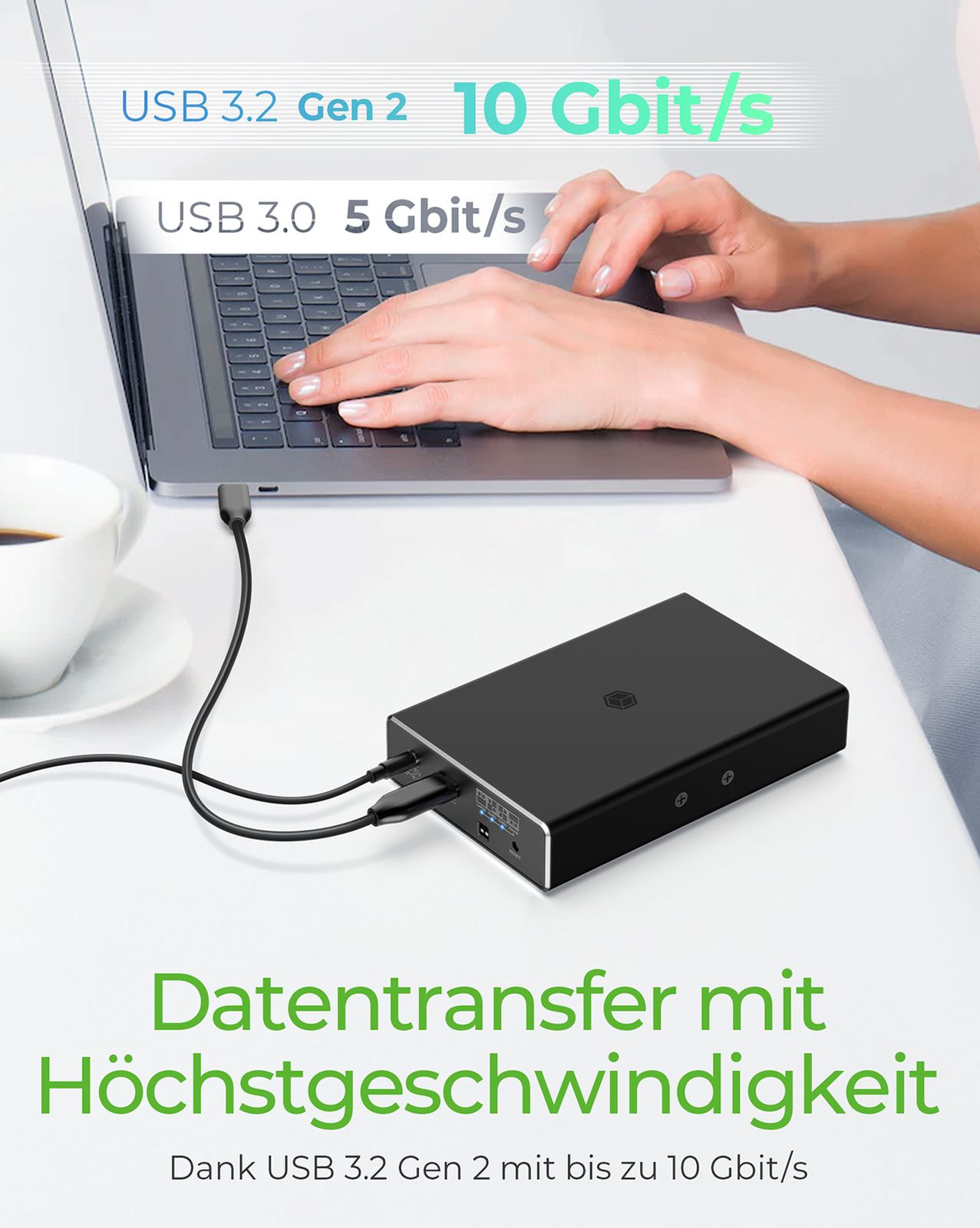 Ein Laptop, ein externes Laufwerk und eine Tasse Kaffee auf einem Schreibtisch.