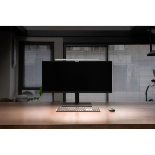 A desk with a monitor, keyboard, and mouse in the foreground.