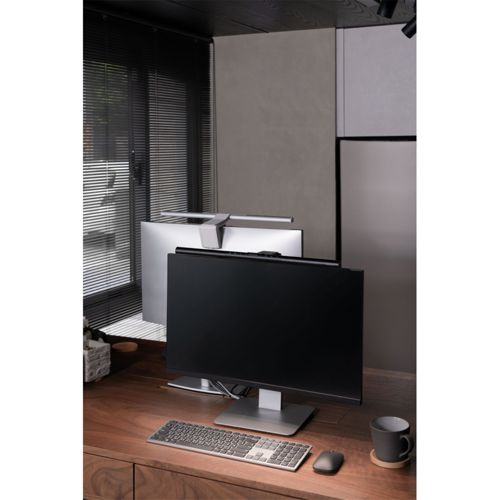 A desk with two monitors, a keyboard, mouse, and mug.
