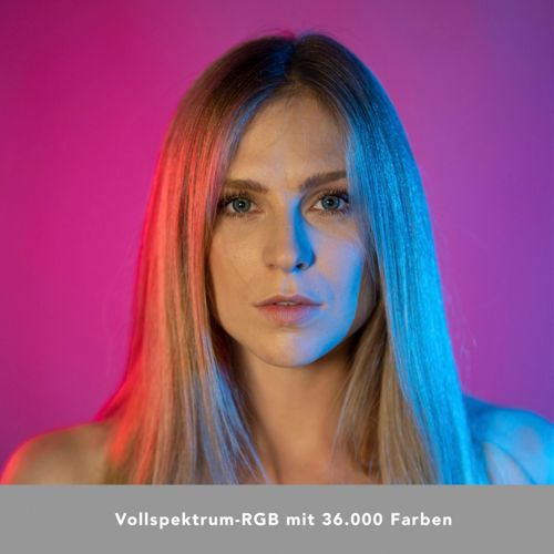 Frau mit blonden Haaren, beleuchtet von roten und blauen Lichtern vor violettem Hintergrund.