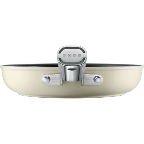 Una sartén color crema con mango de metal pulido y logo de Smeg.