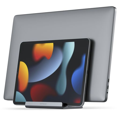 Un MacBook grigio si trova dietro un iPad su un supporto grigio.