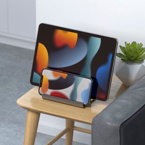 Un tablet e uno smartphone su un tavolo di legno, entrambi con sfondi astratti colorati.
