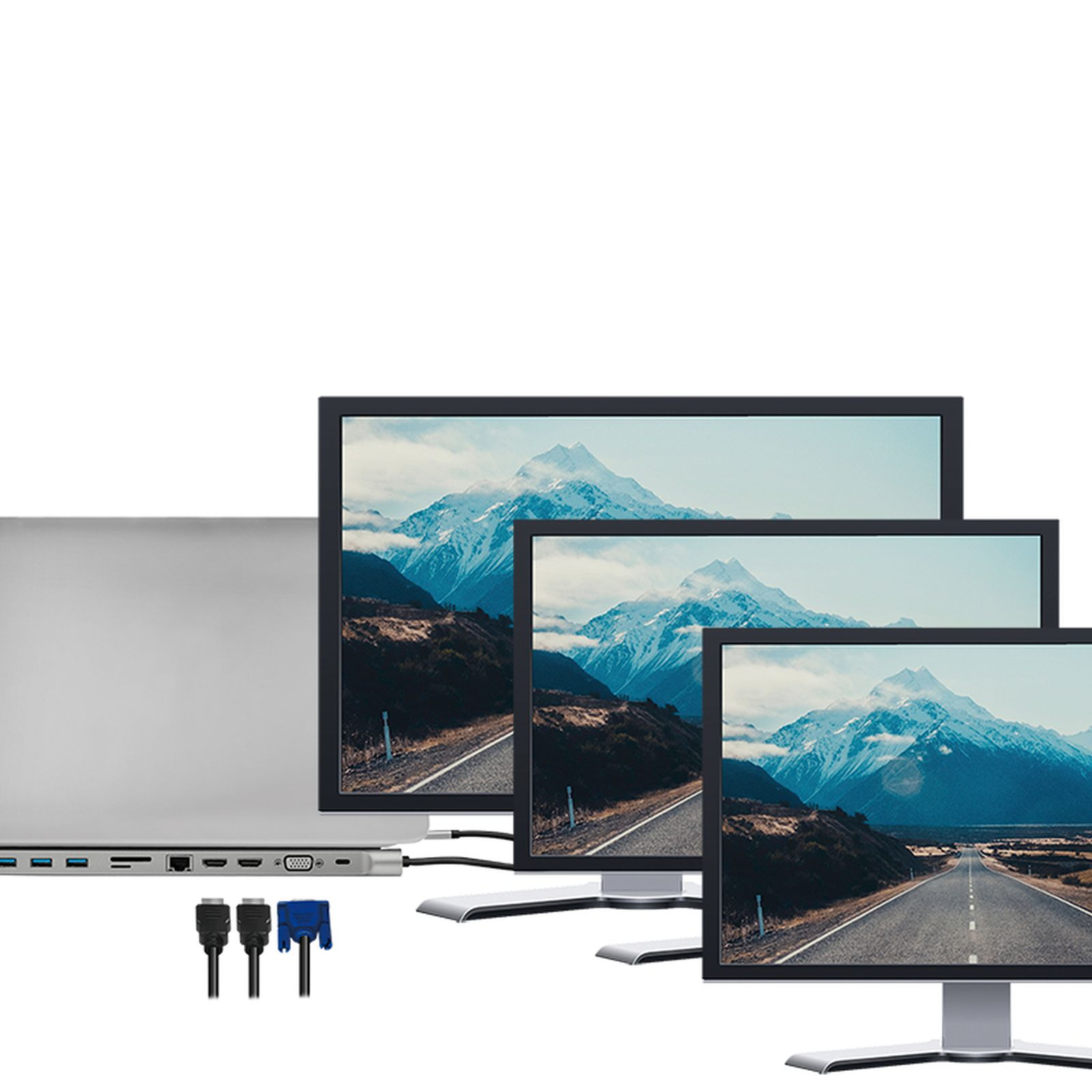 Ein Silber-Laptop mit Dockingstation daneben drei Monitore, die Berge zeigen.