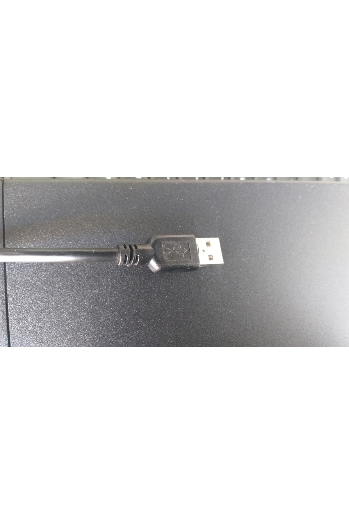 Koyu, dokulu bir yüzeyde konektörlü siyah bir USB kablosu.