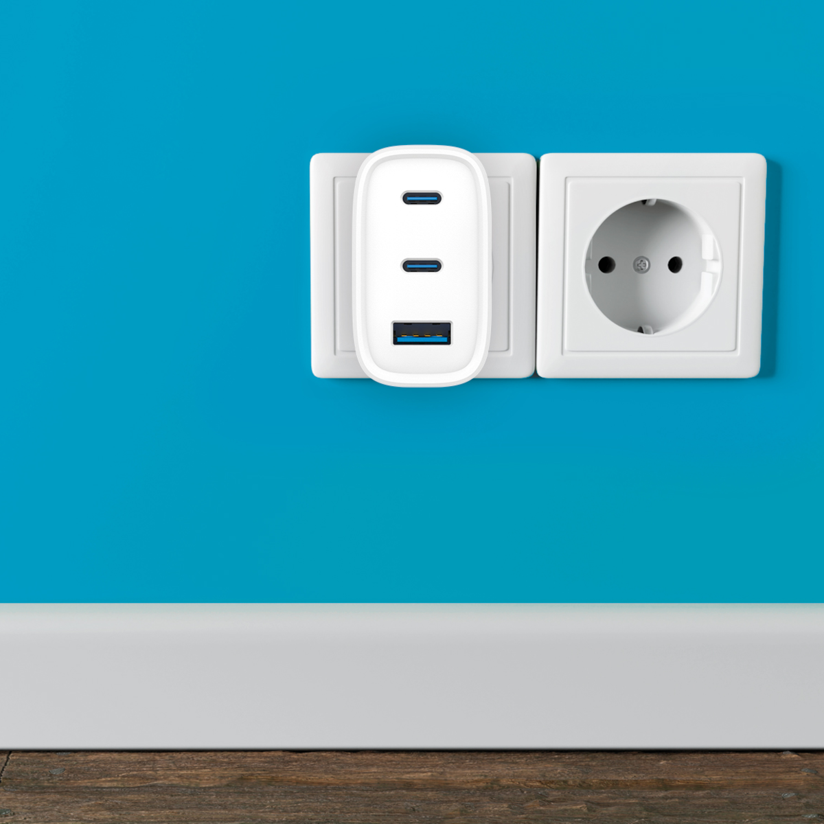 Un cargador USB-C blanco con tres puertos está enchufado en un enchufe.