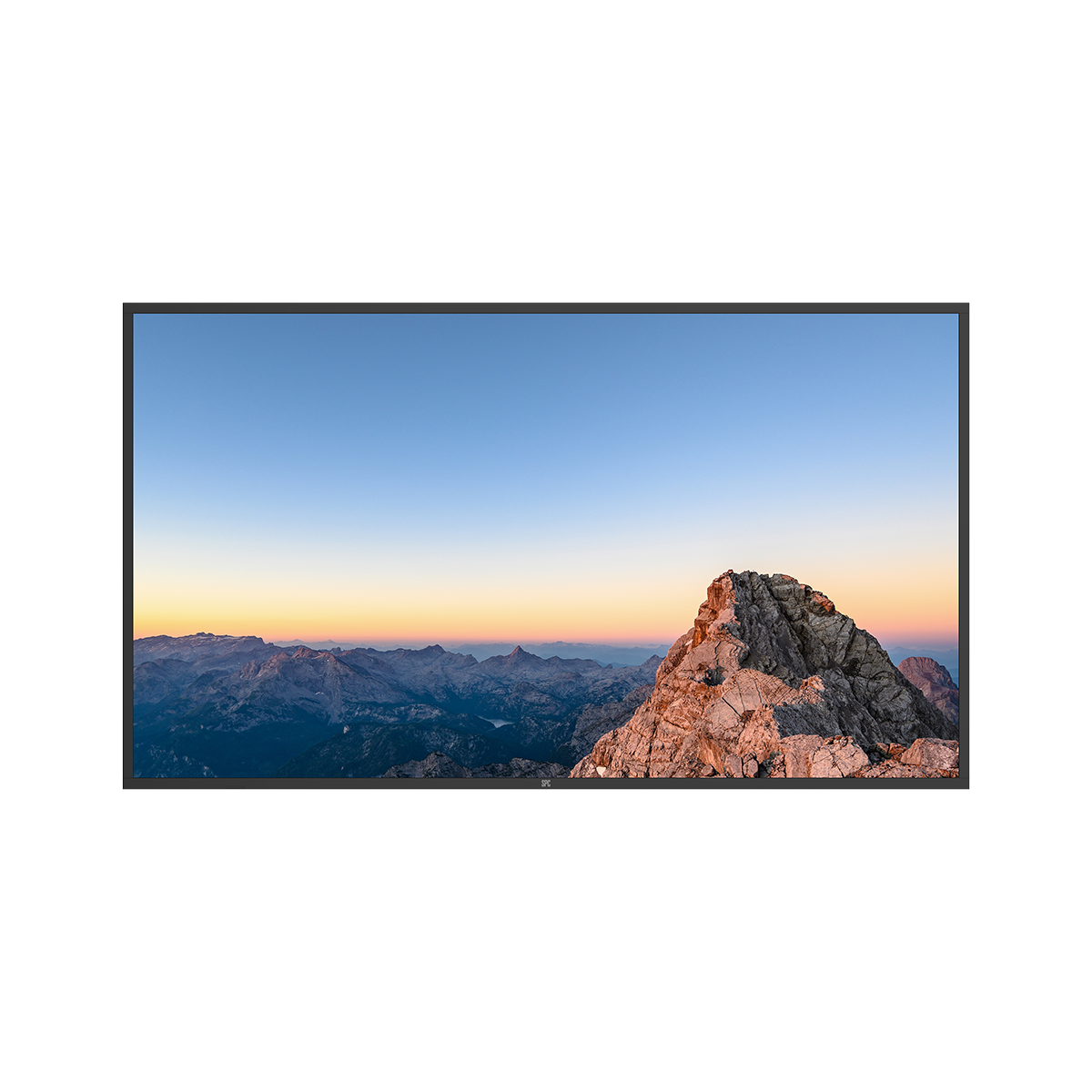 Cordillera montañosa al amanecer con un pico rocoso en primer plano y cielo azul.