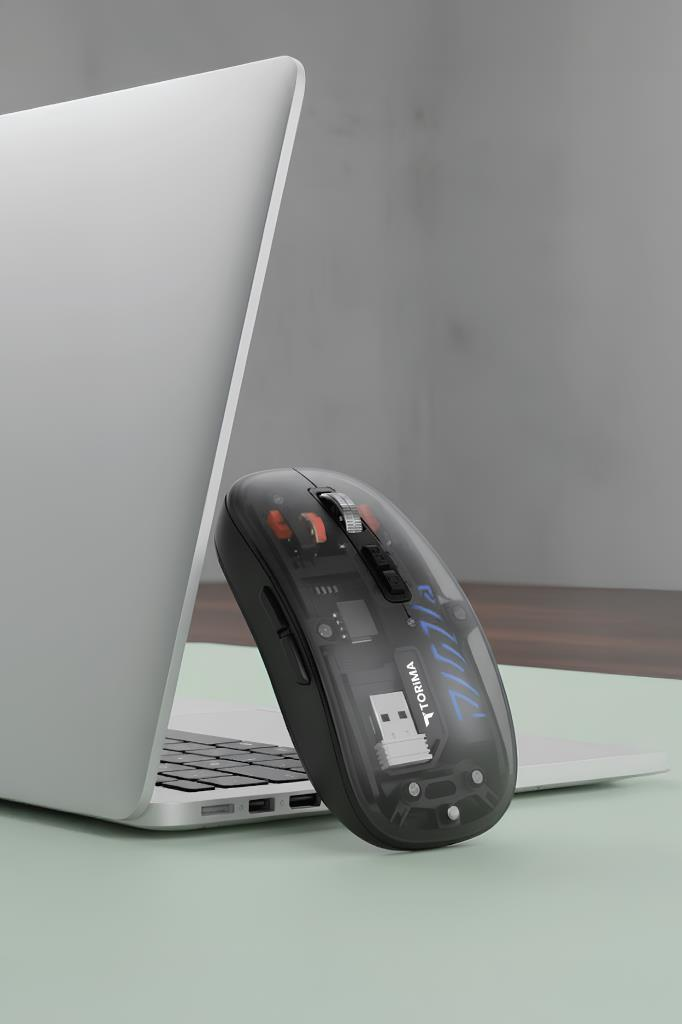 Laptopun yanında şeffaf bir oyuncu faresi. Farenin iç bileşenleri görünür durumdadır.