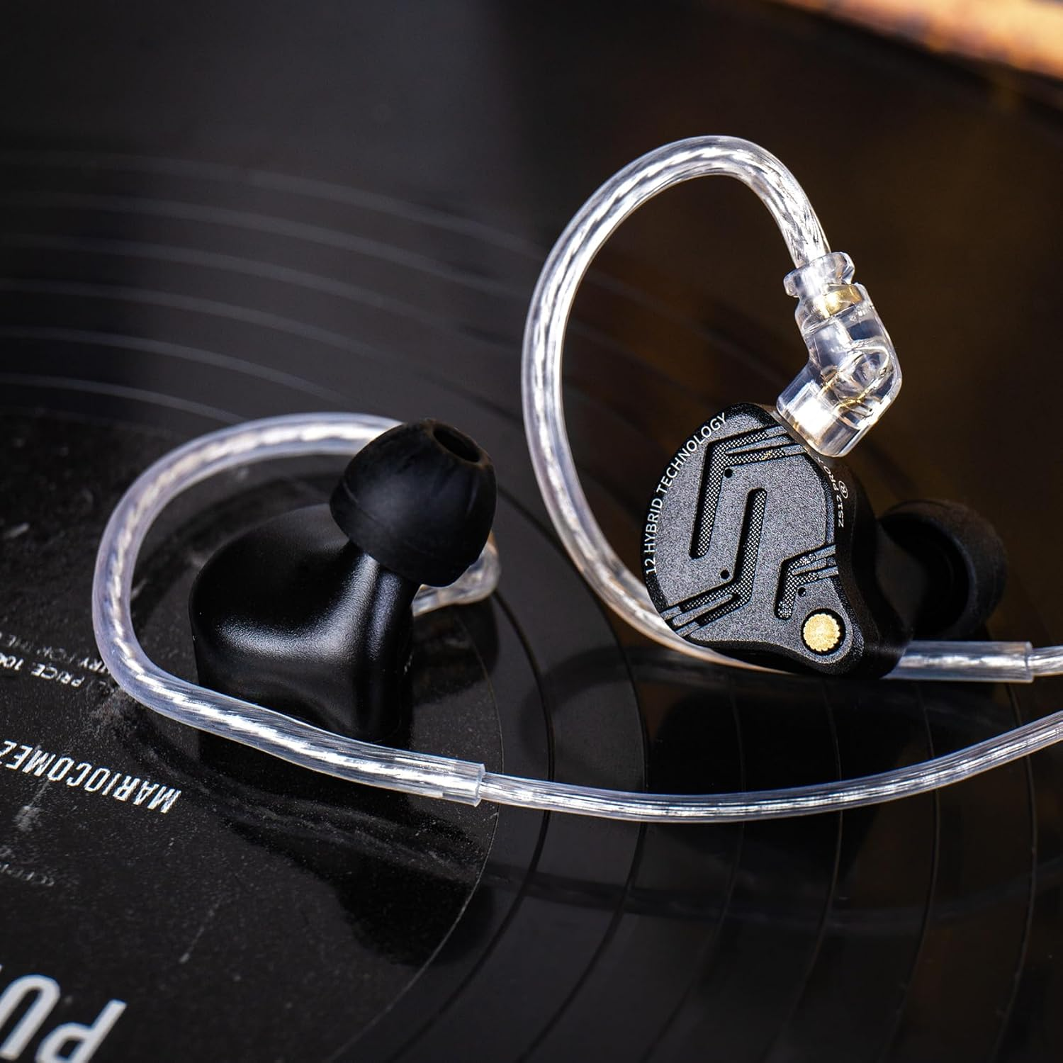 Écouteurs noirs avec câble transparent reposant sur un disque vinyle.