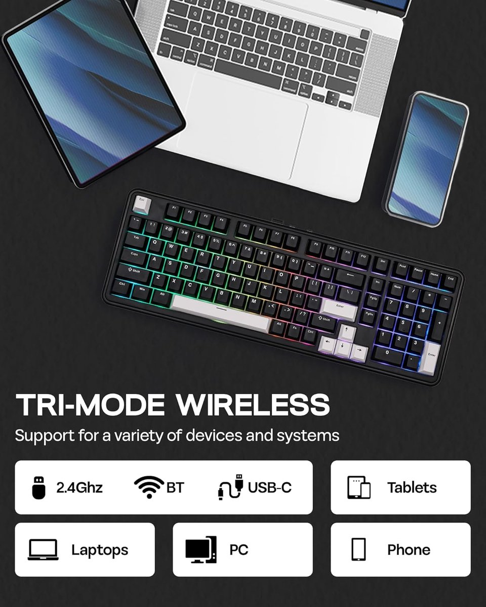 Zwart toetsenbord met RGB-verlichting op een bureau met laptop, tablet en telefoon.