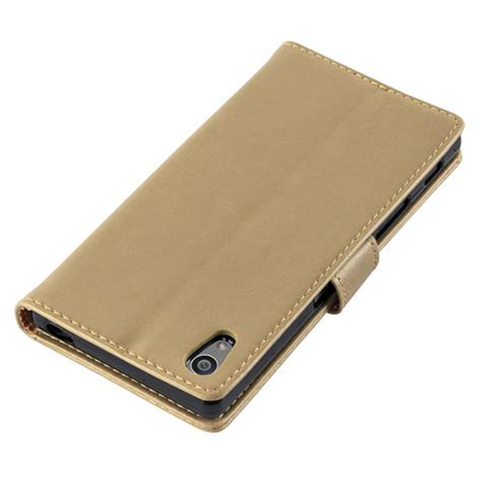 Una custodia a libro dorata per telefono con la fotocamera visibile sul retro.