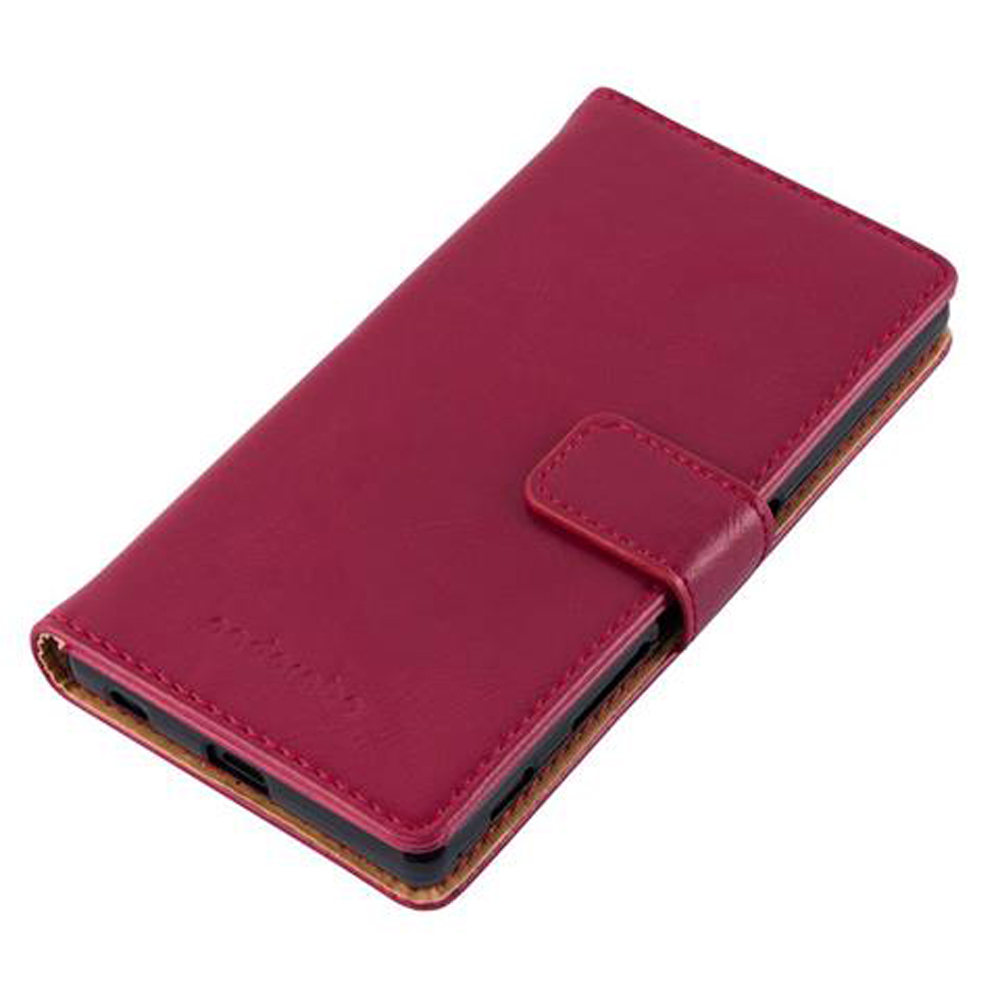 Una custodia a libro in pelle rosso scuro per smartphone, chiusa con cinturino.
